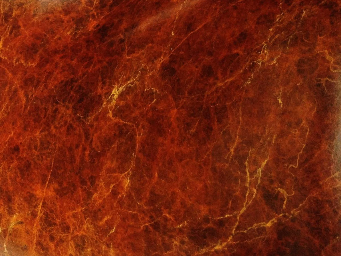 Abstract rich orange-brown patina with yellow veining on a metal surface