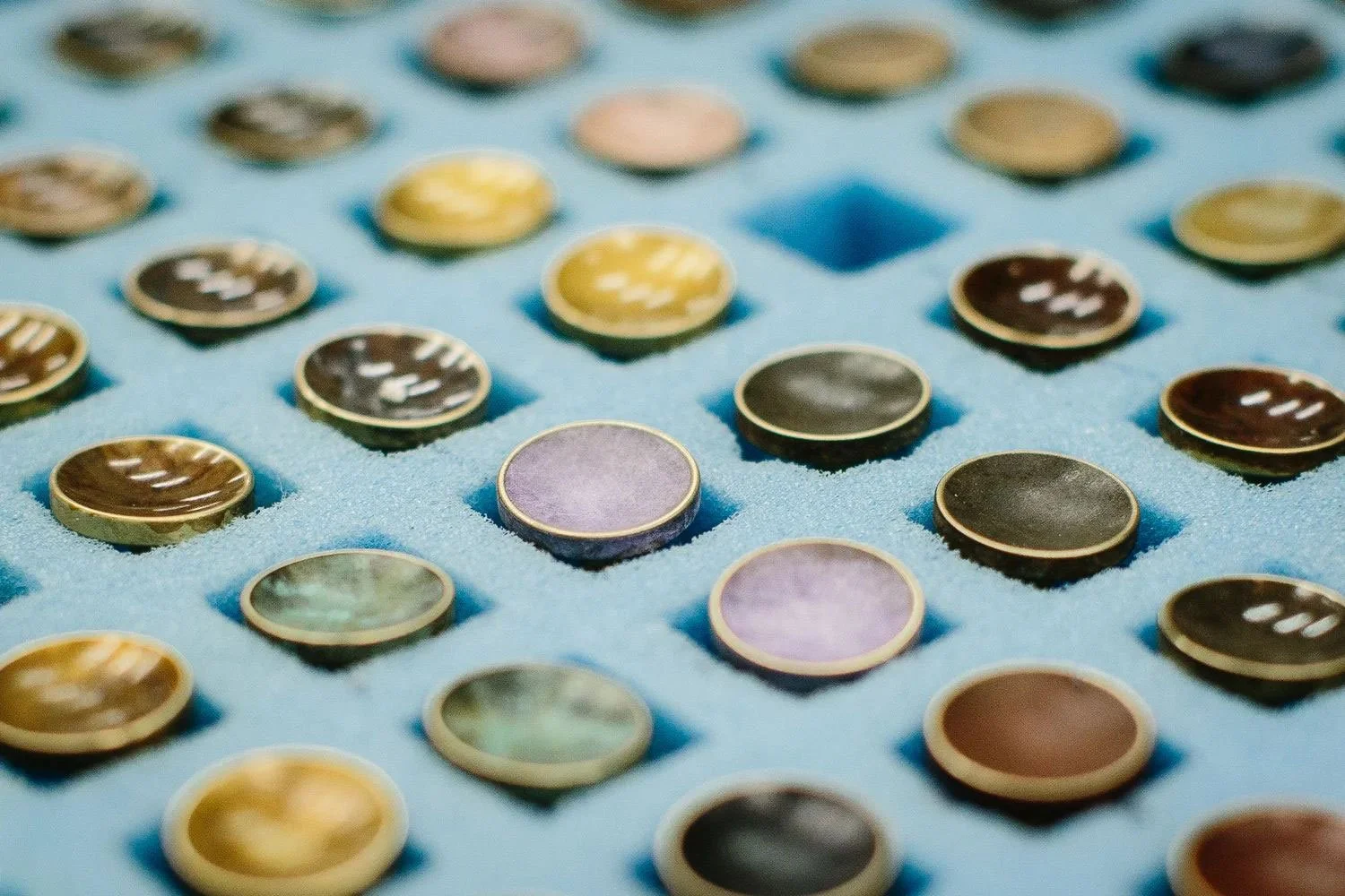 Close up of metal cufflinks patinated in different colours designed by Alice Made This