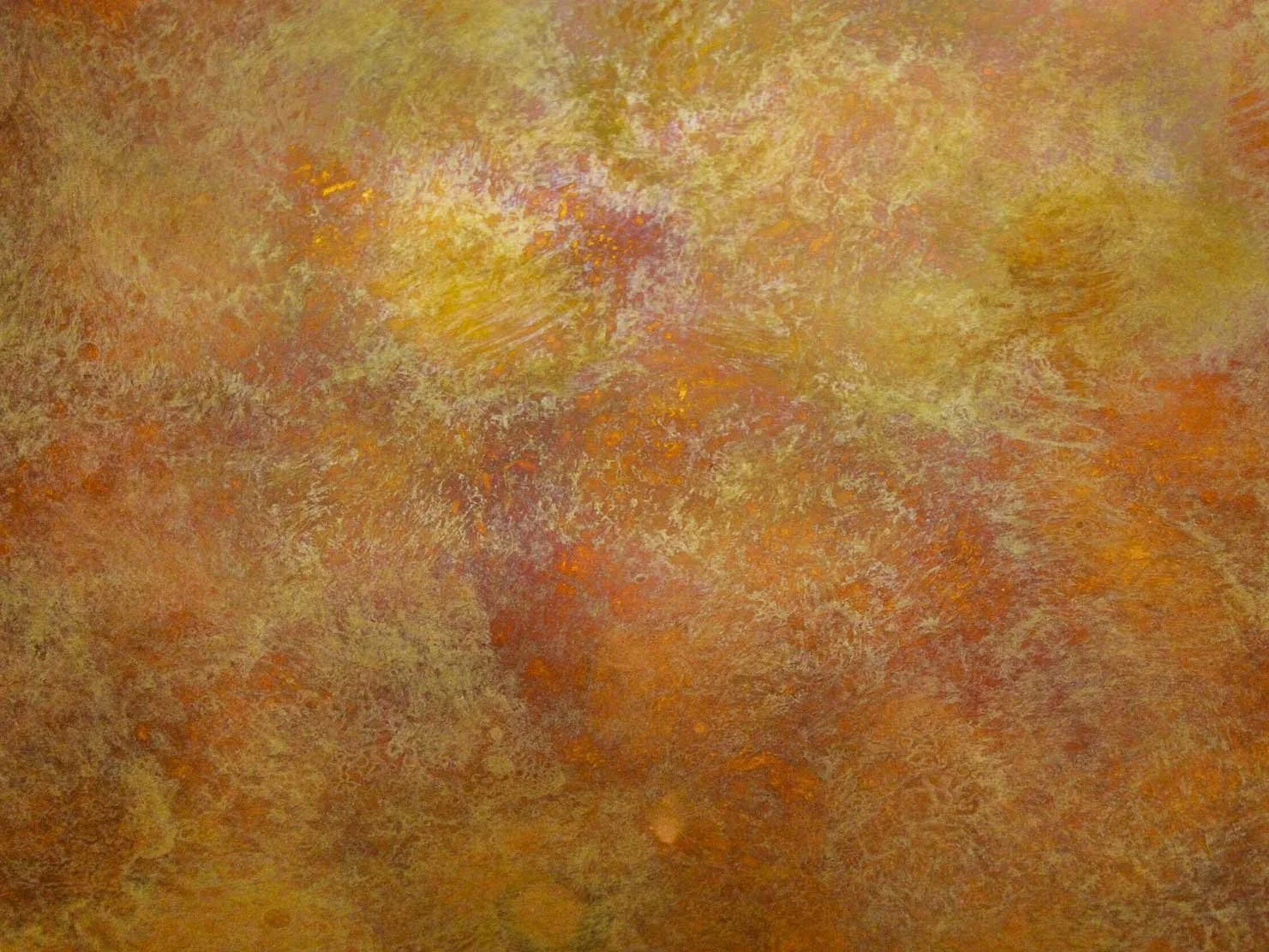Abstract patina texture with layered ochre, yellow and rust tones on metal surface