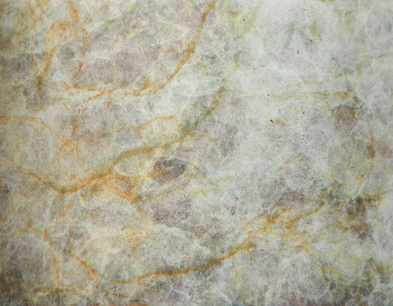 Subtle grey patina on metal with fine surface texture and traces of yellow veining