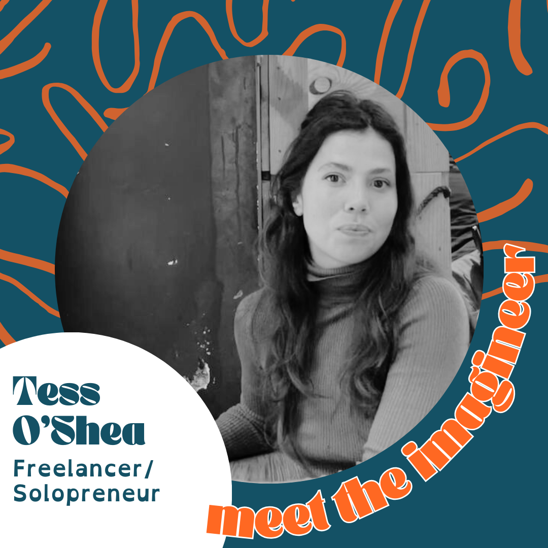 Black and white photo of Tess O'Shea, a woman with long dark hair, wearing a ribbed top, sitting indoors with wooden walls in the background. The image is part of a graphic introducing her as a freelancer and solopreneur.