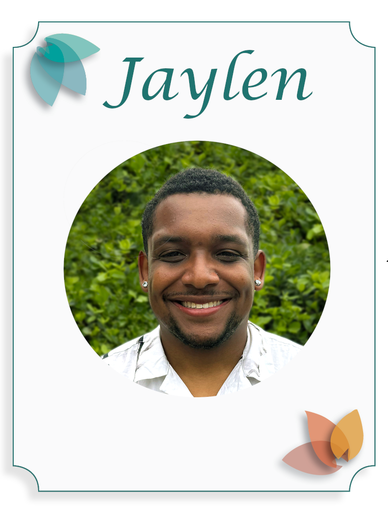 A smiling man with short curly hair and earrings, wearing a white shirt, standing outdoors with green foliage in the background, on a name badge with the name Jaylen.
