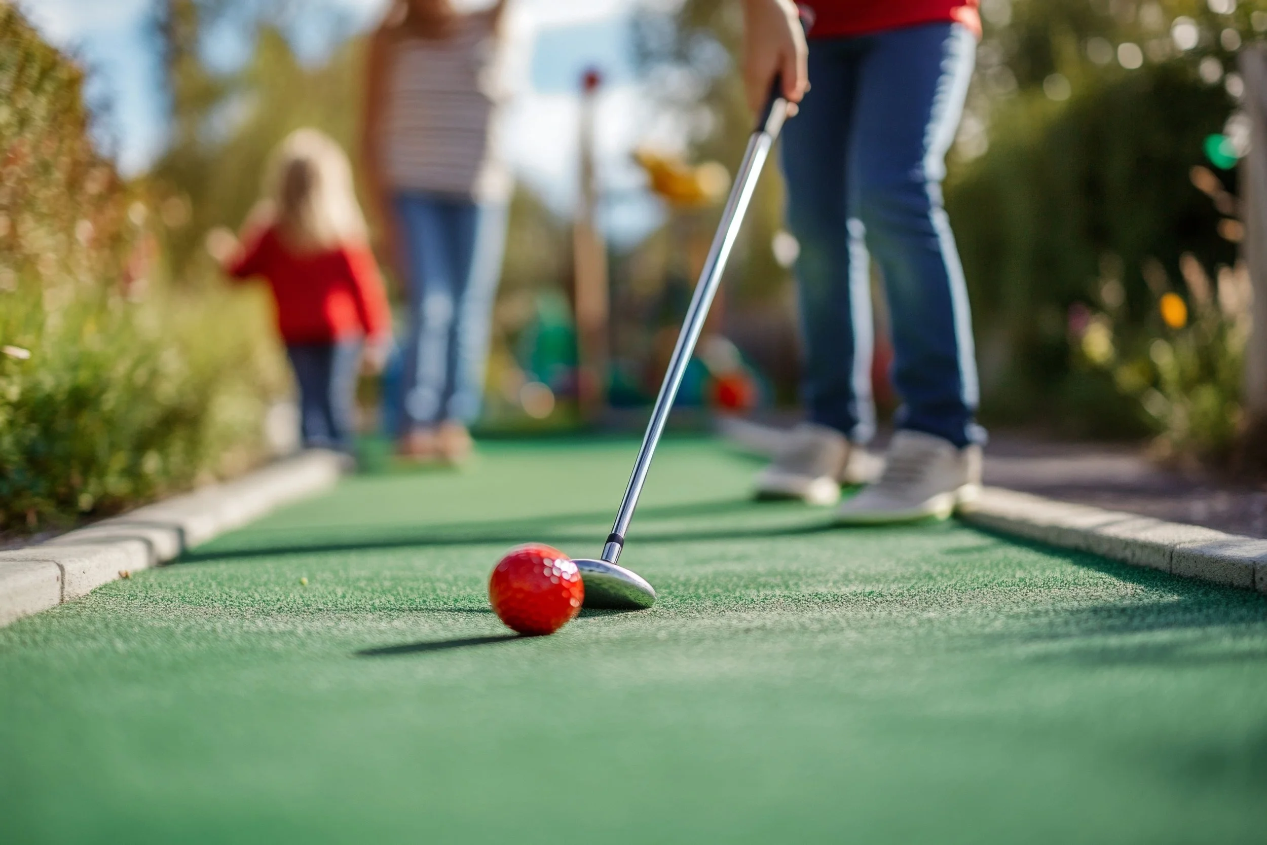 Making a putt at Sea Island Mini Golf
