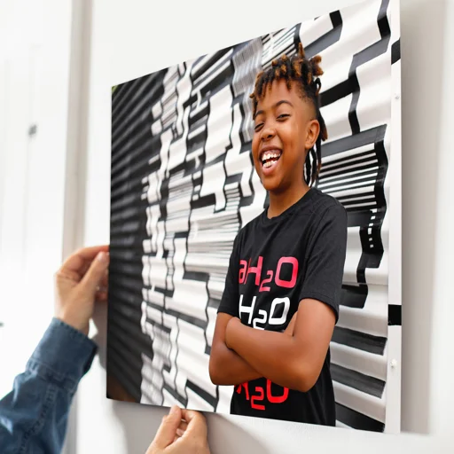 A young girl with styled hair standing in front of a black and white abstract wall art, smiling and crossing her arms.