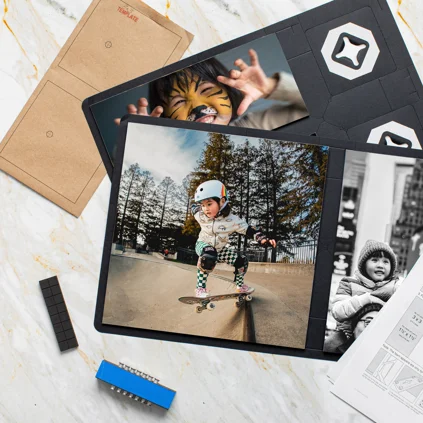 Children's photos and art supplies on a white table, including a tablet showing a girl skateboarding and a photo of a girl in a knit hat.