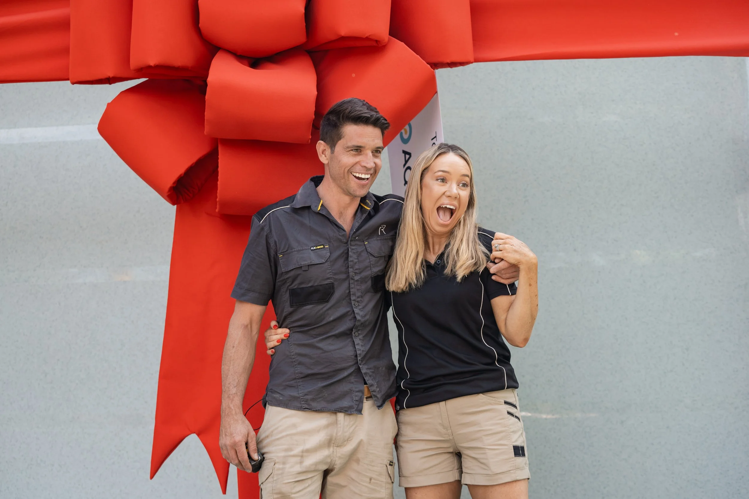 Rachel and Ryan with their big Aquify Pool with a bow around it while filming their TV show Holiday Home Makeover with Rachel & Ryan, The R&R Design Co.