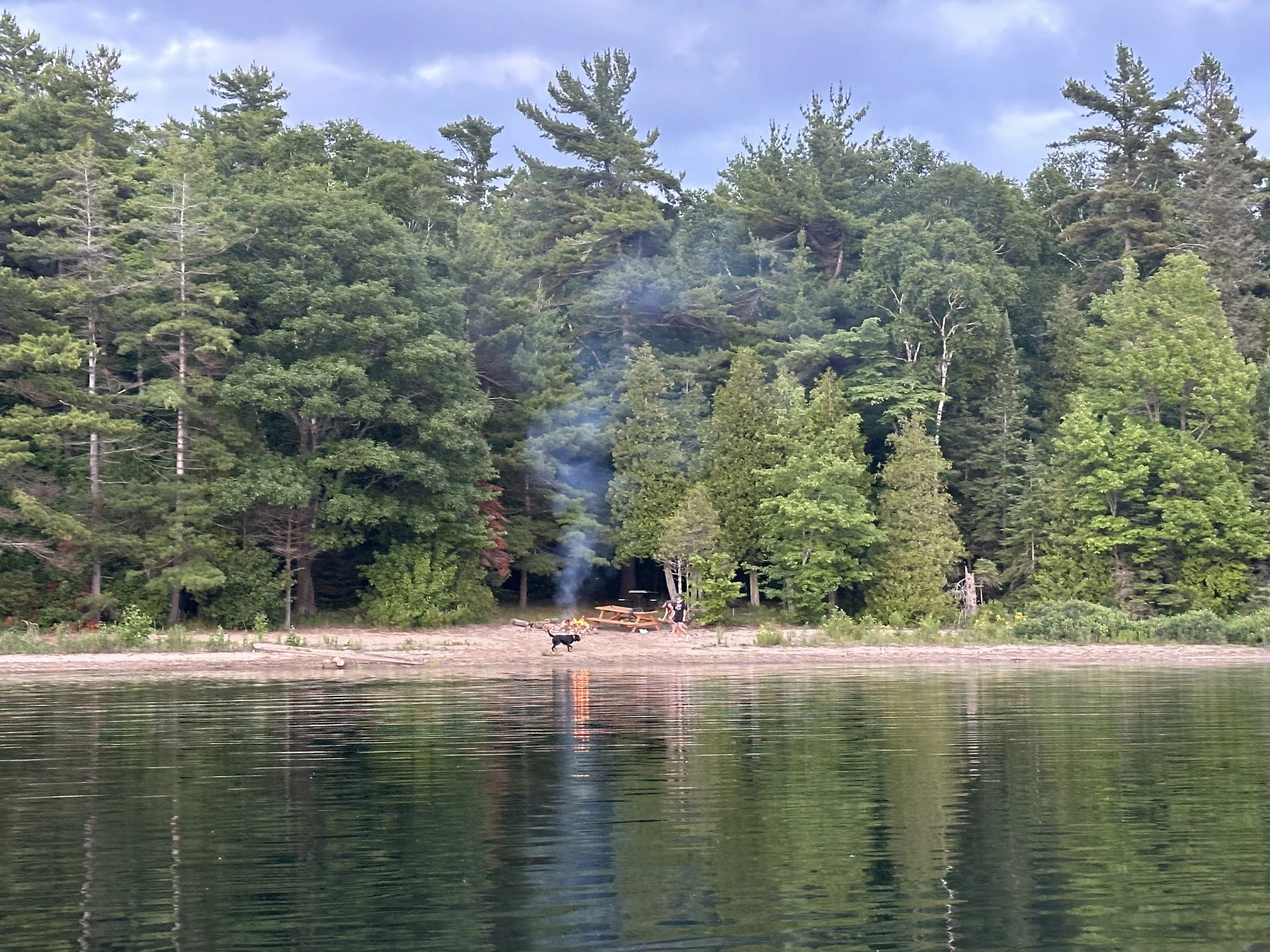 Fire ablaze on shore with kids and Kona