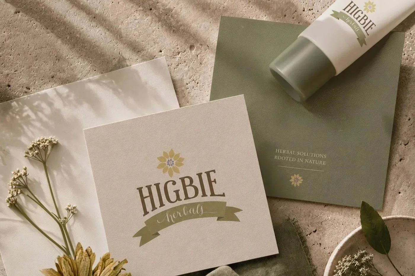 HIGBIE Herbals product box and tube with herbal solutions branding, surrounded by dried flowers and leaves on a textured surface.