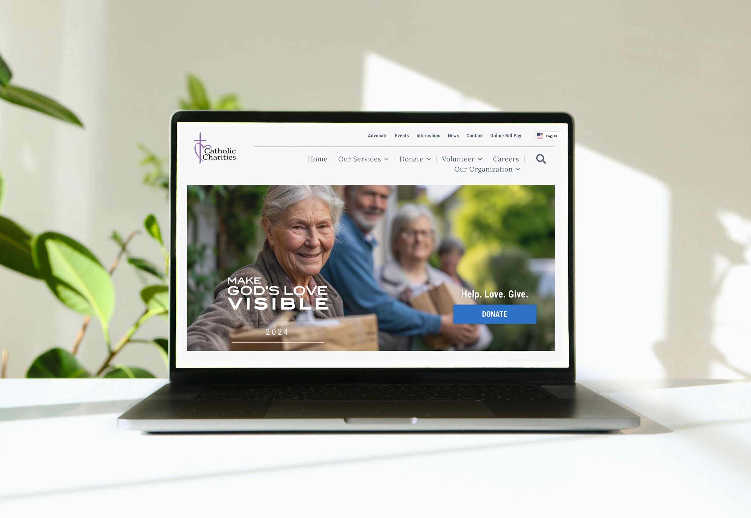 Website design for a non-profit displaying seniors and donation options. Green plant leaves are visible on the left side, and natural sunlight illuminates the scene.