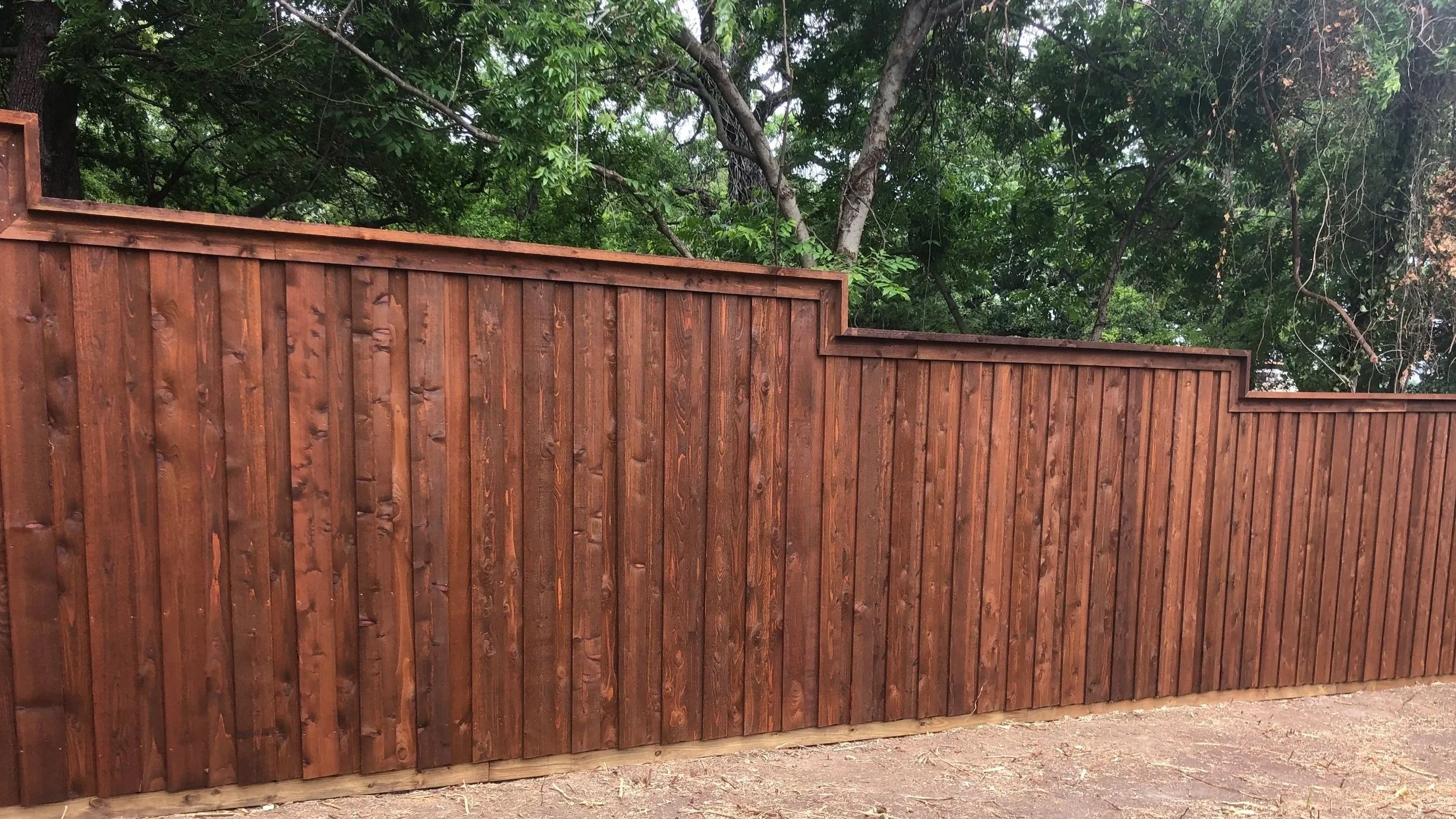 A tall wooden privacy fence made of vertical planks.
