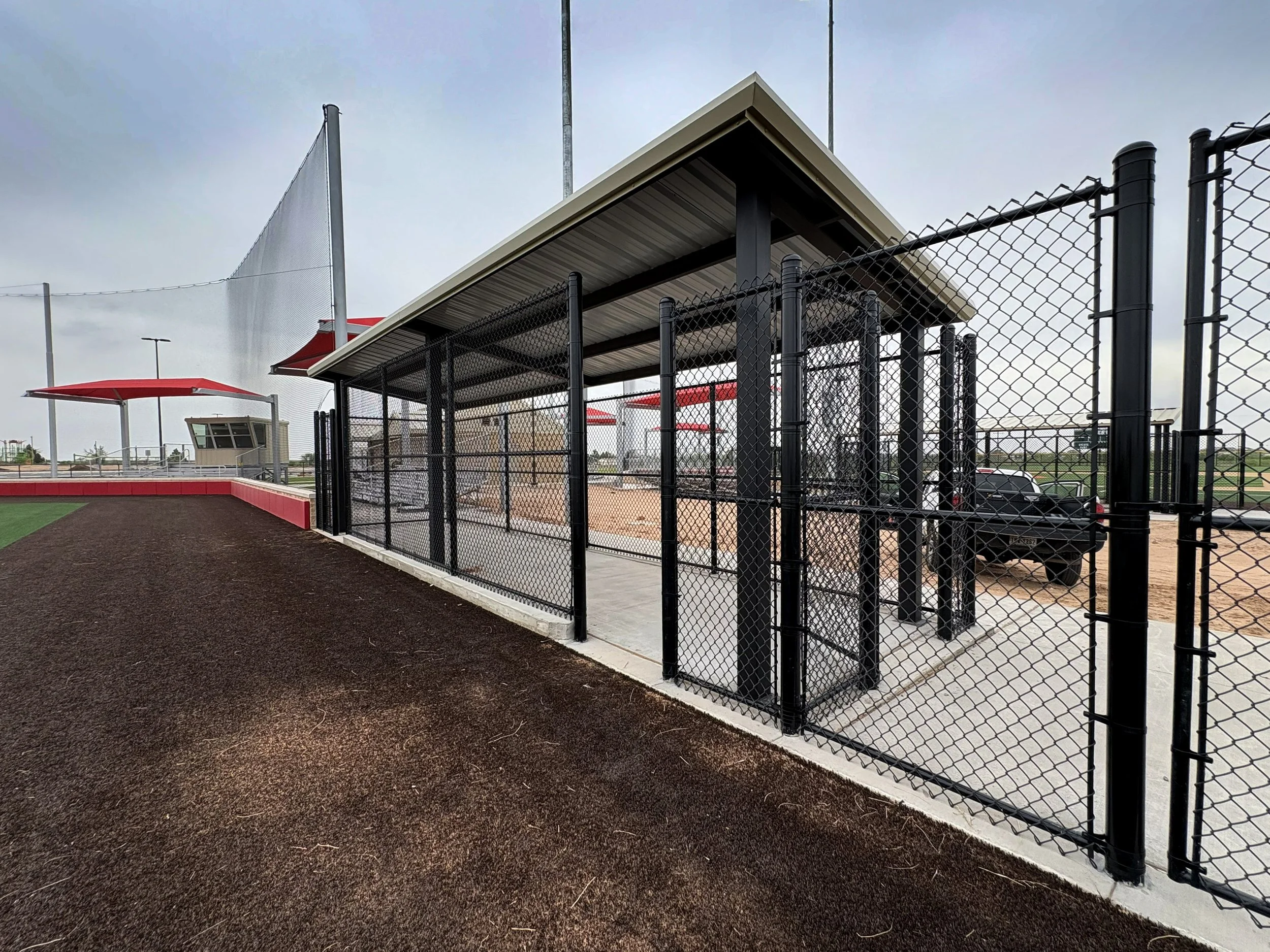 Iron fenced baseball dugout by Rustic Fence.