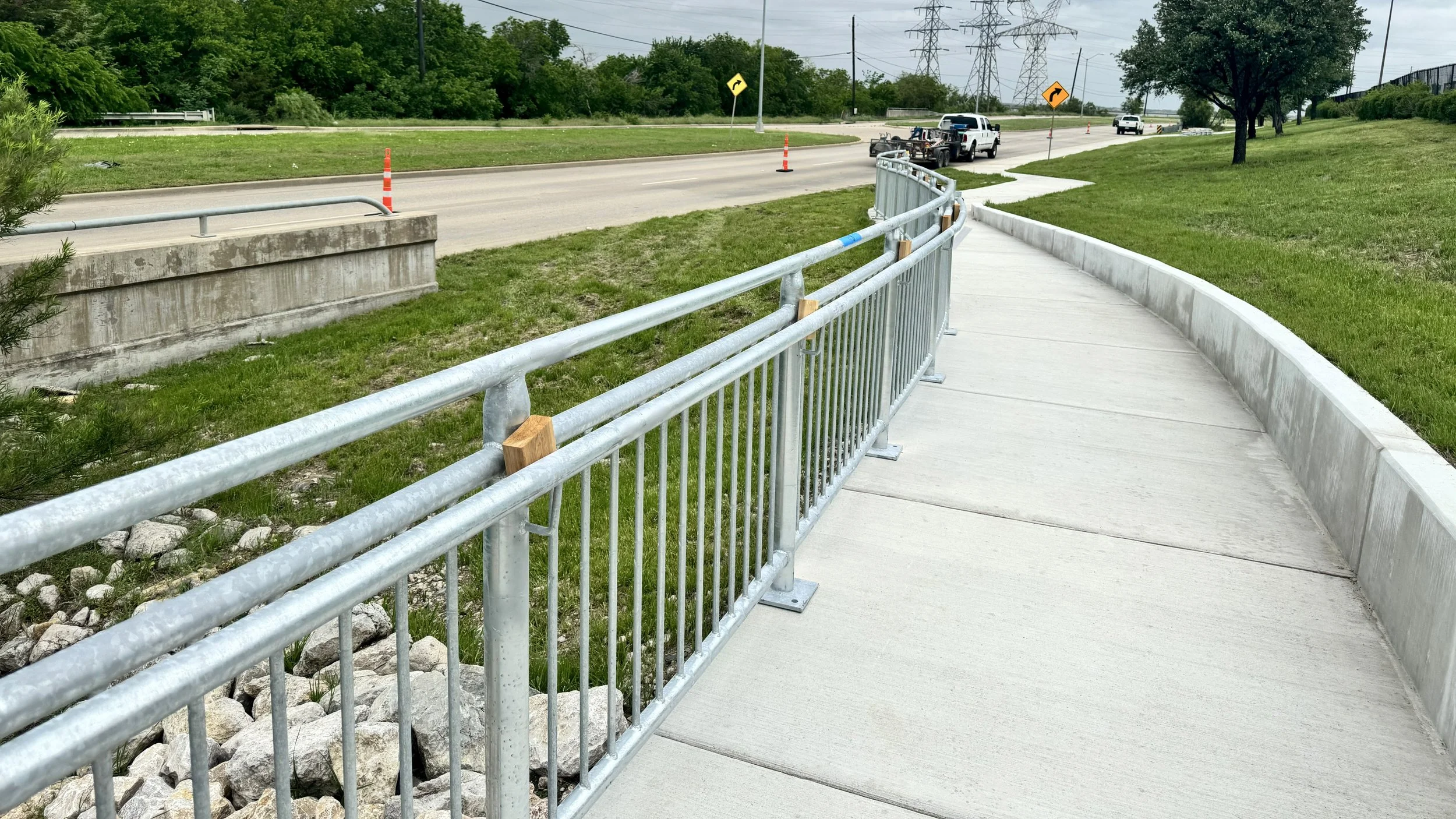 Curved sidewalk with steel handrail made by Rustic Fence & Steel.