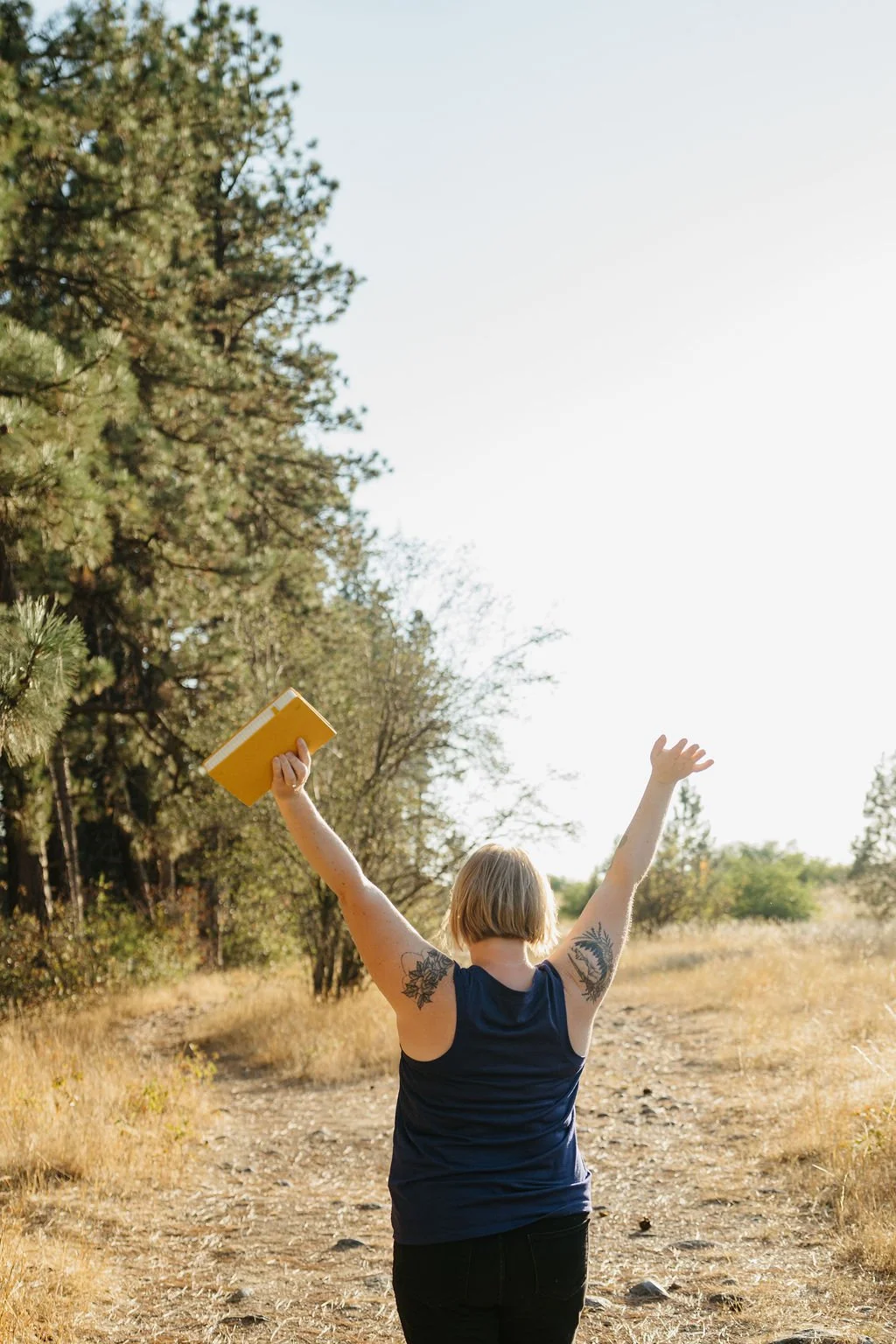 Woman lifting her arms on an empty road.