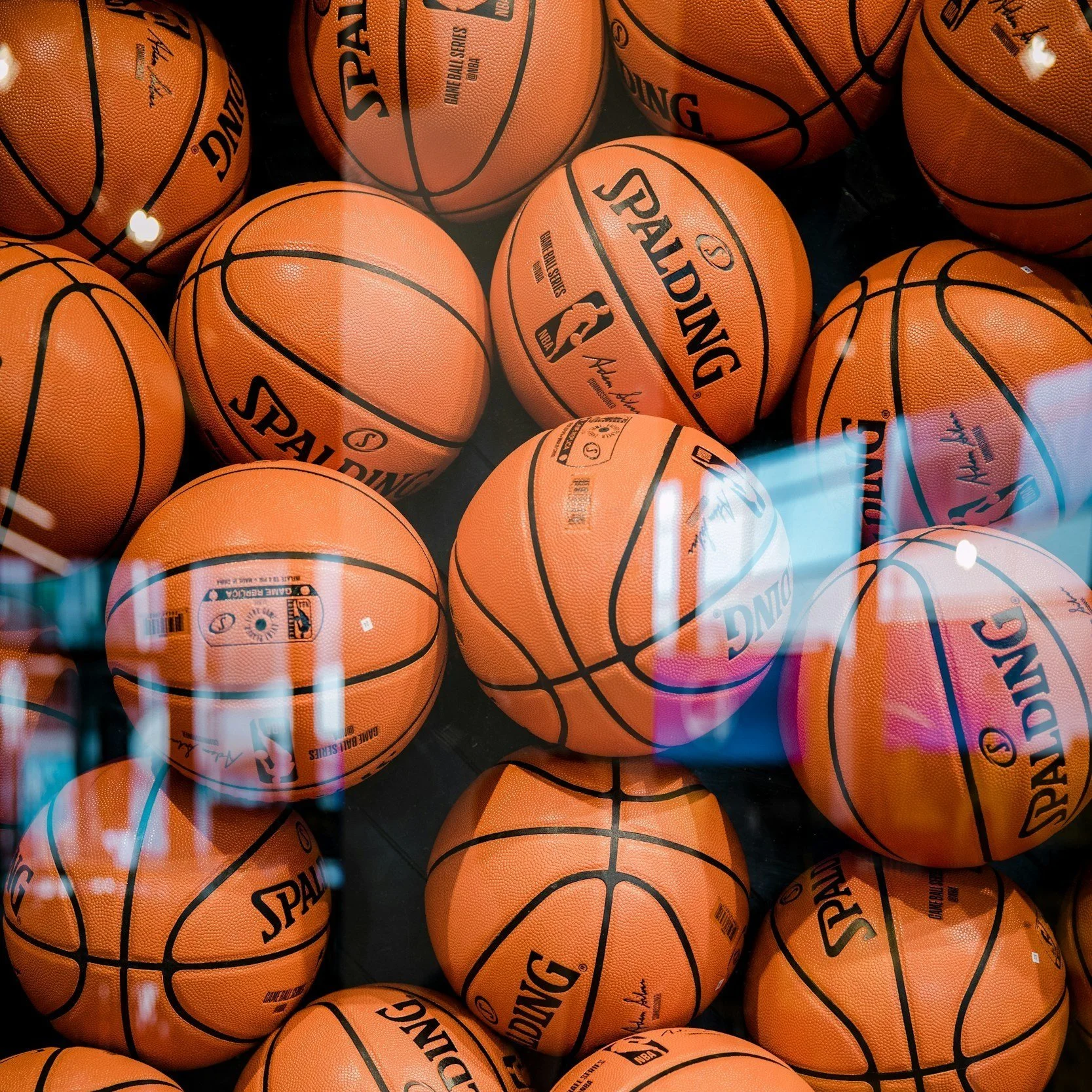 Multiple orange Spalding basketballs with black lines, stacked for display.