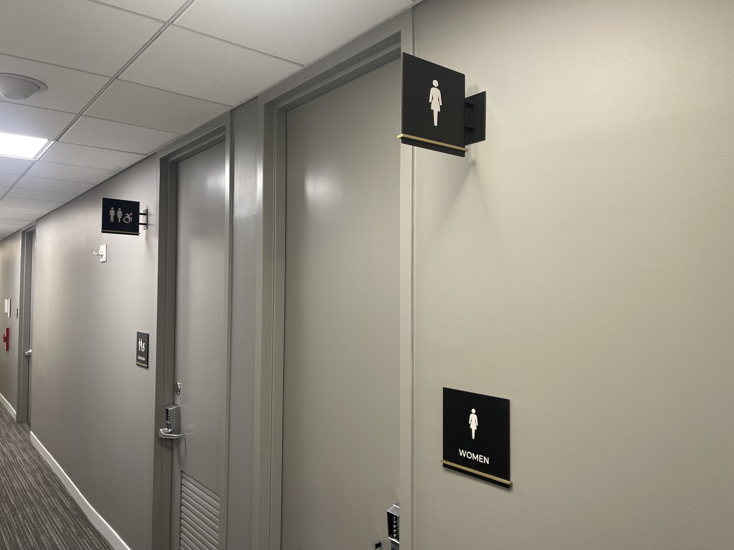 Restroom signage for CBRE Group with custom bronze detailing