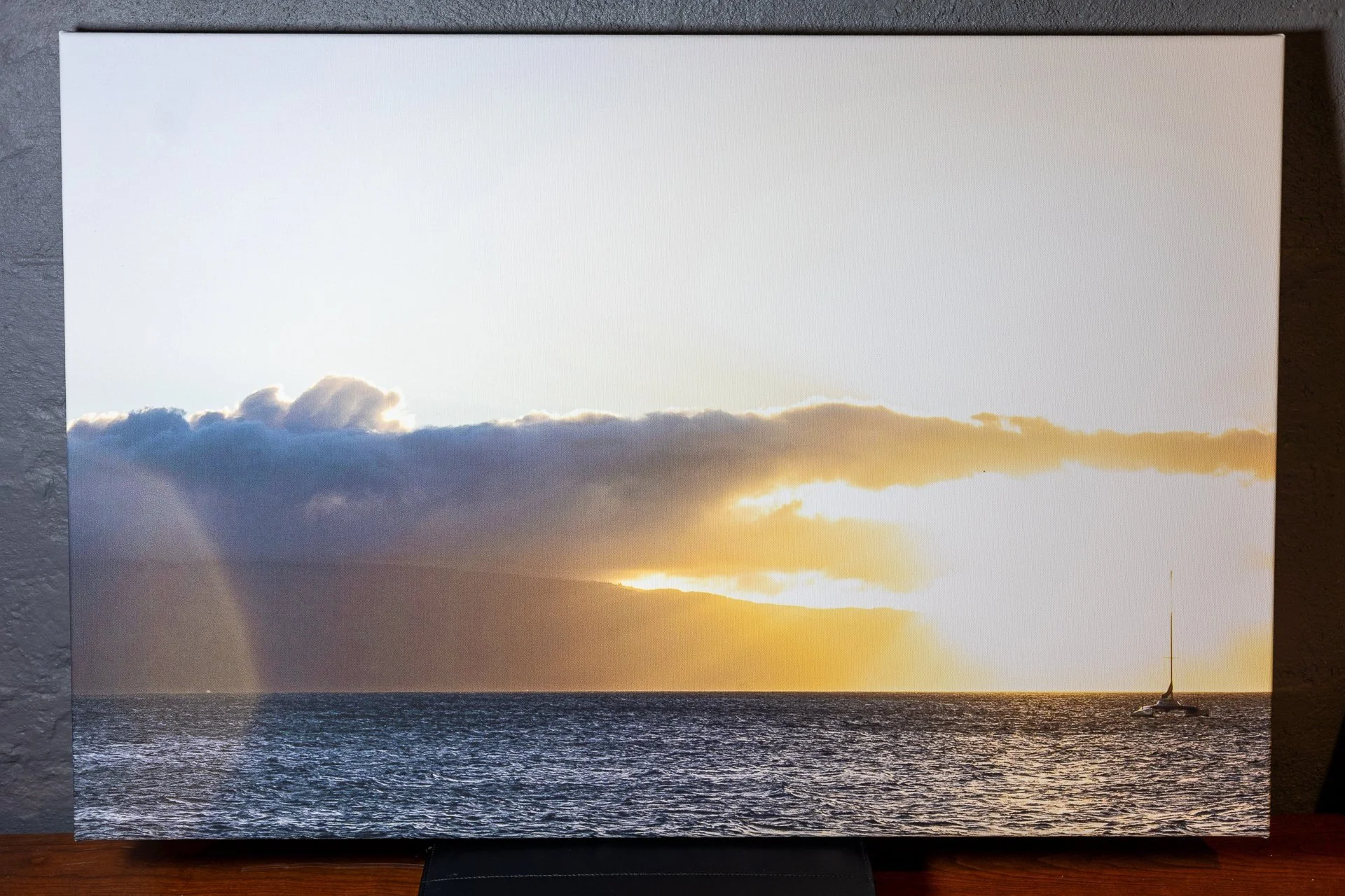 Sunset over the ocean with scattered clouds and a sailboat on the water. Metal photography prints available for home decor and wall art.