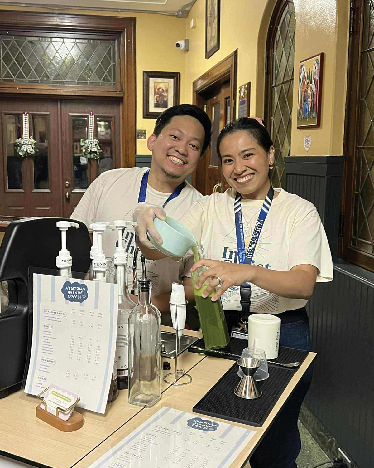 Aries and Anna, owners of Newtown Avenue Coffee, serving drinks at a community event espresso bar in New York