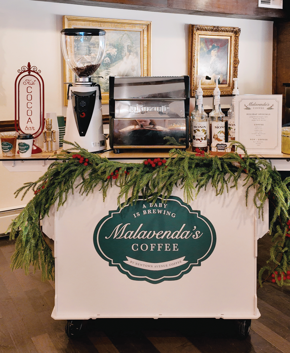 Hot coco, coffee, and matcha cart catering setup at a baby shower on Long Island with custom cup stickers and cart cover