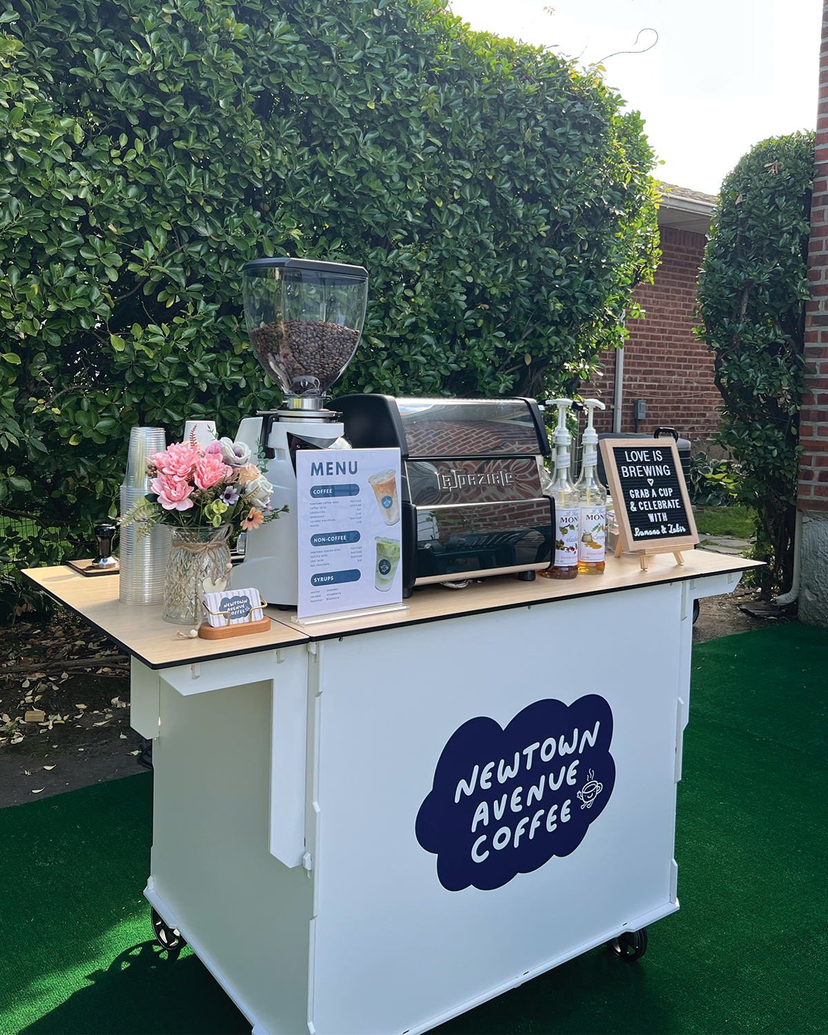 Newtown Avenue Coffee espresso cart fully set up at an outdoor pre-wedding ceremony in New York