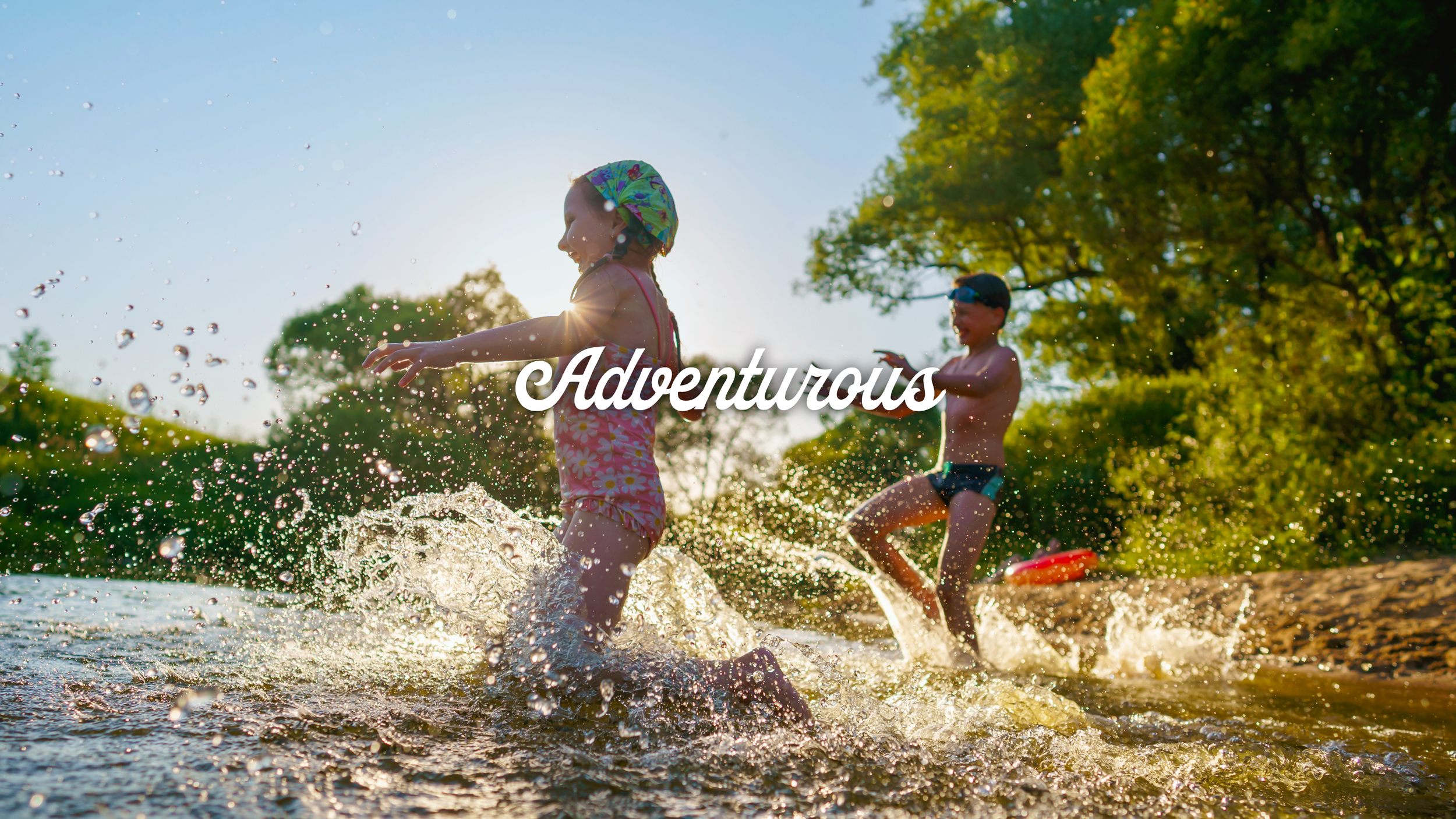 Children running and splashing in river during summer afternoon