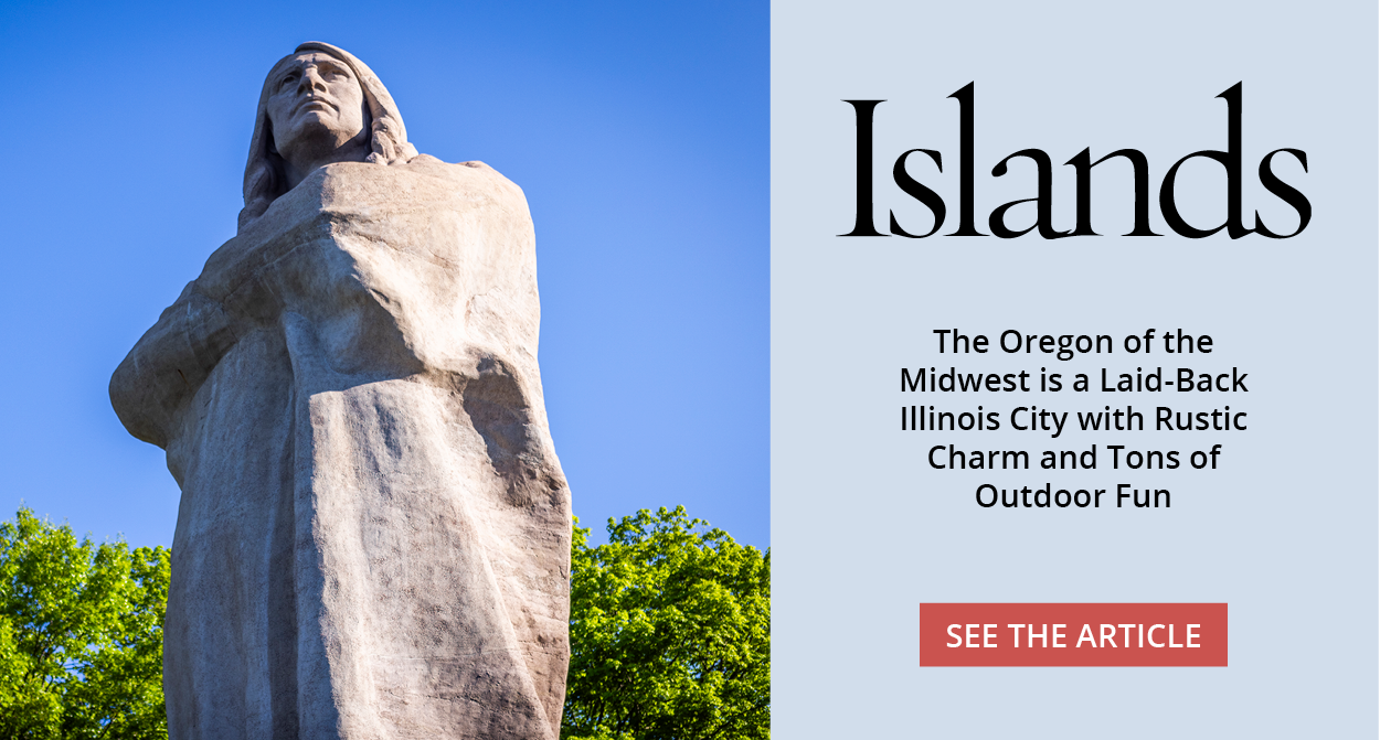 Photo of the Statue of Liberty with a blue sky background and green trees in the foreground. The image includes text about islands in Oregon, describing it as a laid-back city with rustic charm and outdoor fun, and features a button labeled 'See the Article'.