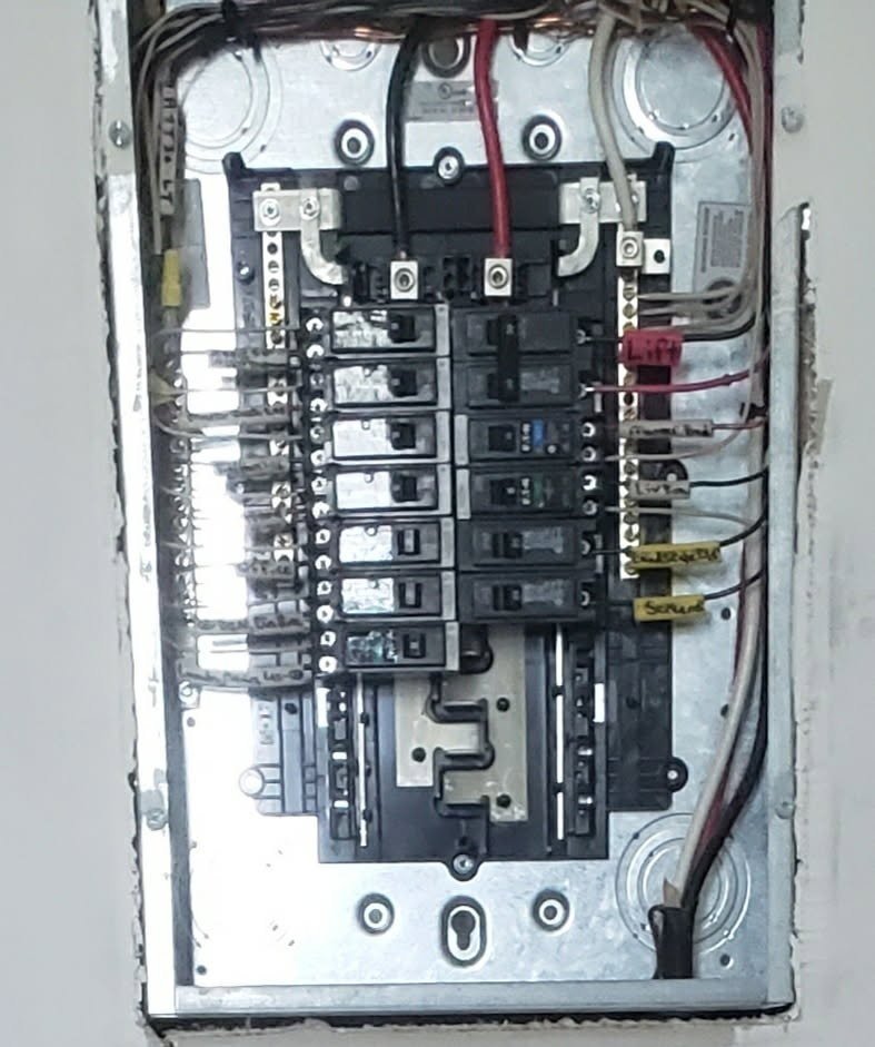Another new electrical circuit breaker panel with multiple breakers, wires connecting to terminals labeled neatly!