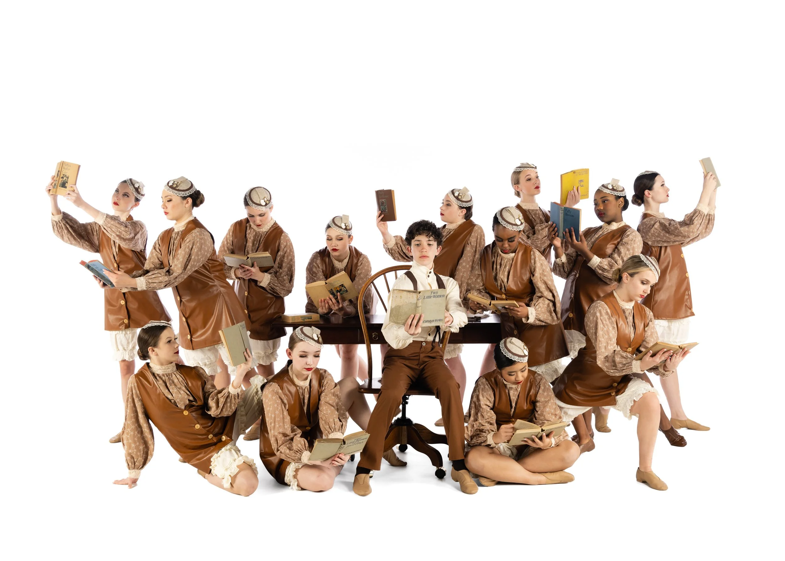 Group of women and children dressed in vintage-style clothing, holding books, some standing, some sitting, on a white background.