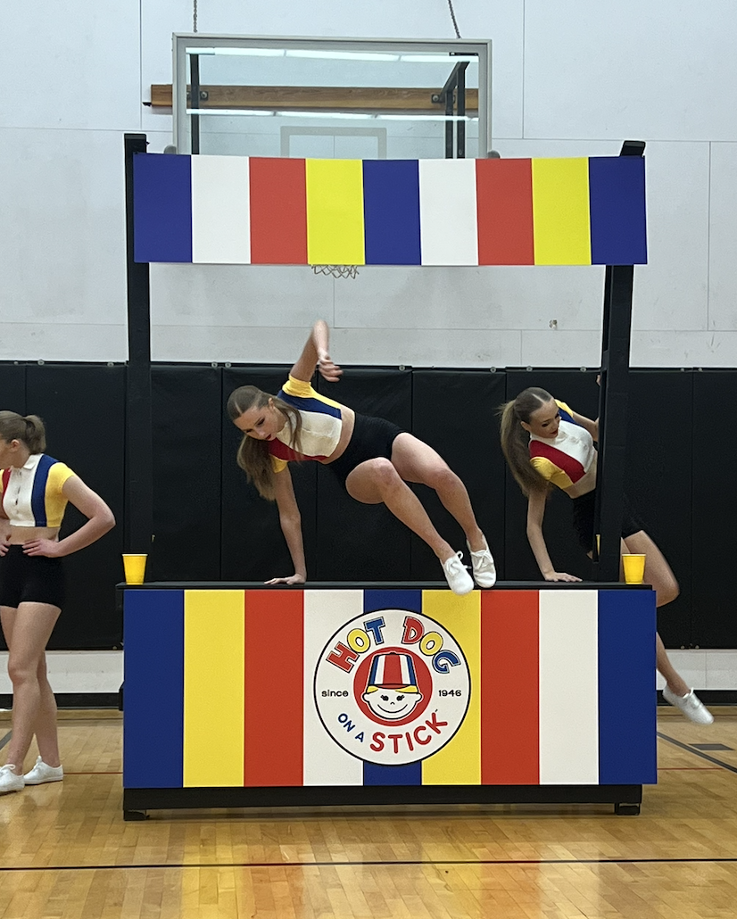 Cheerleaders performing on a colorful 