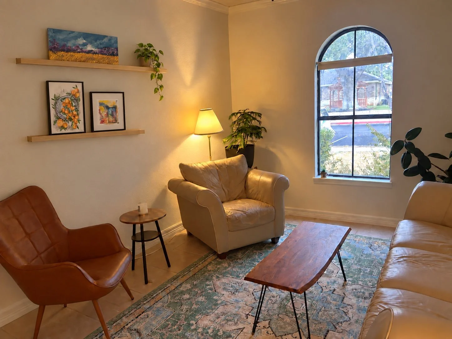 Another view of the Desert Streams Counseling office in Round Rock, Texas, showing comfortable seating, artwork, and an arched window.
