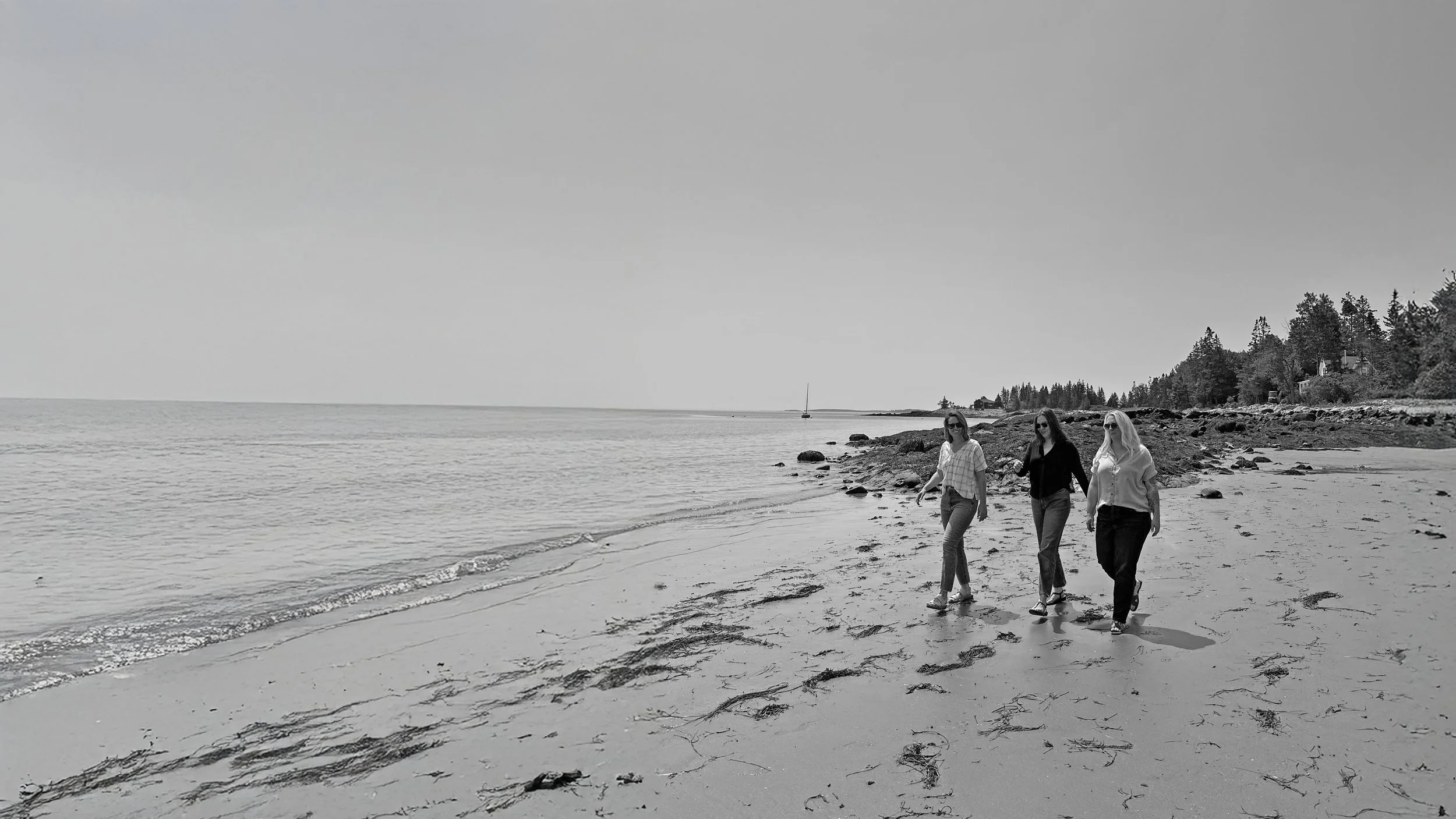 Three WRKroom team members walking on the Midcoast Maine beach