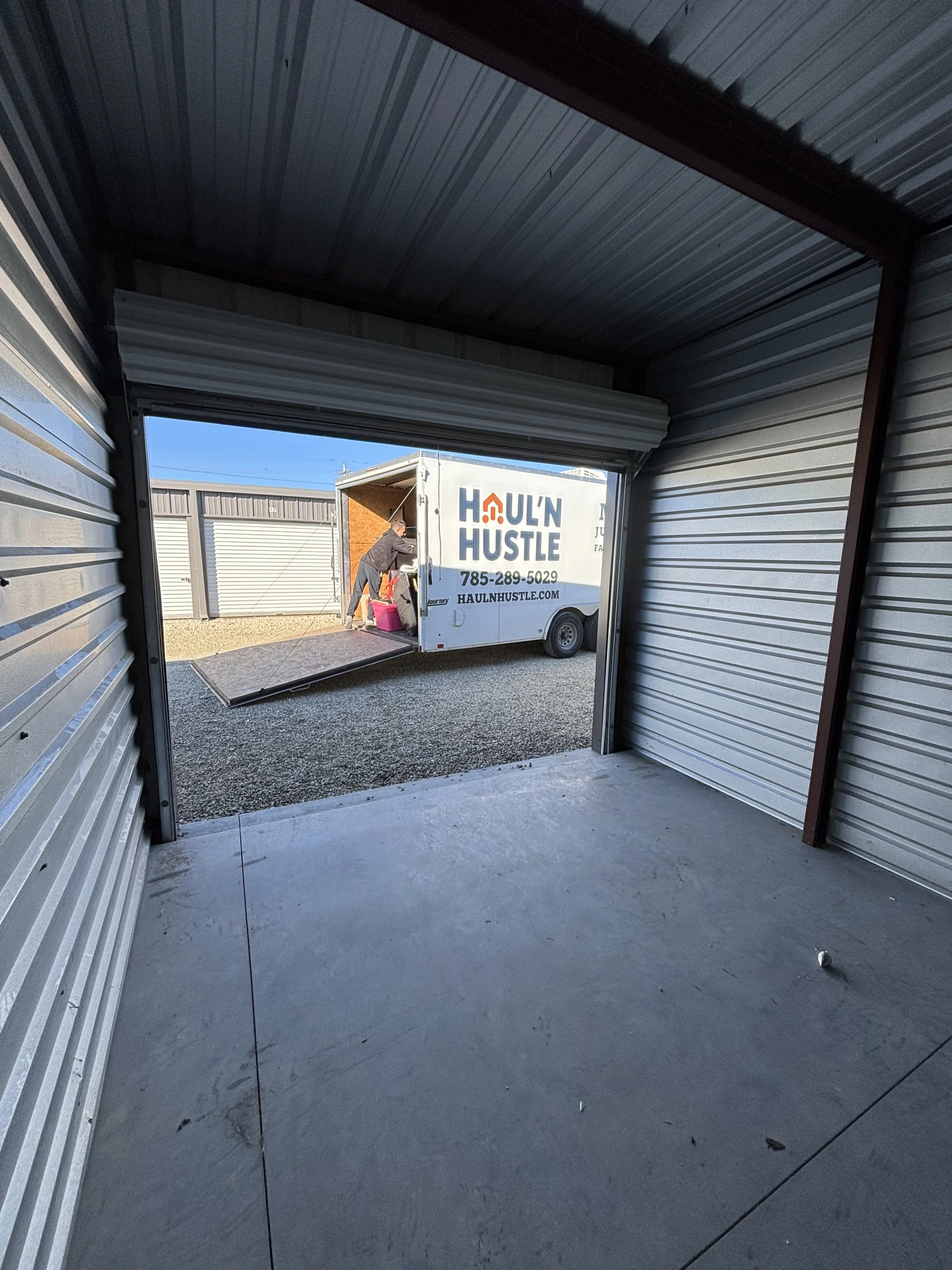 Person moving boxes in a modern office or apartment with large windows