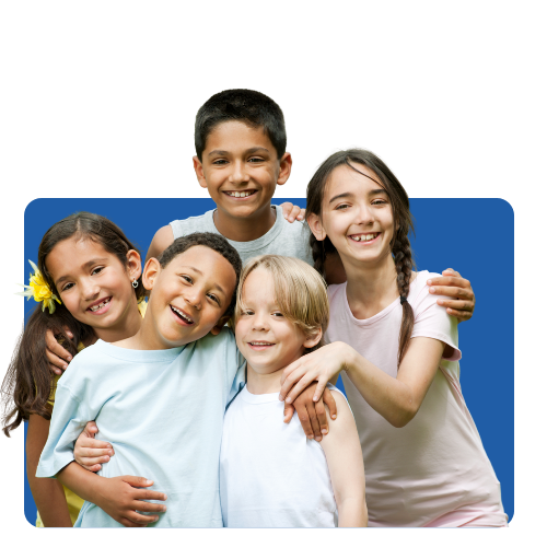 Group of five smiling children outdoors, hugging each other.