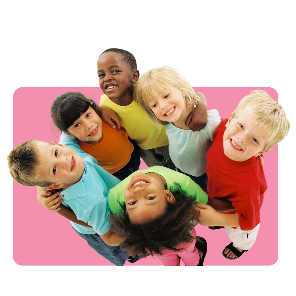 Group of six children smiling and looking up at the camera, standing close together on a pink background.
