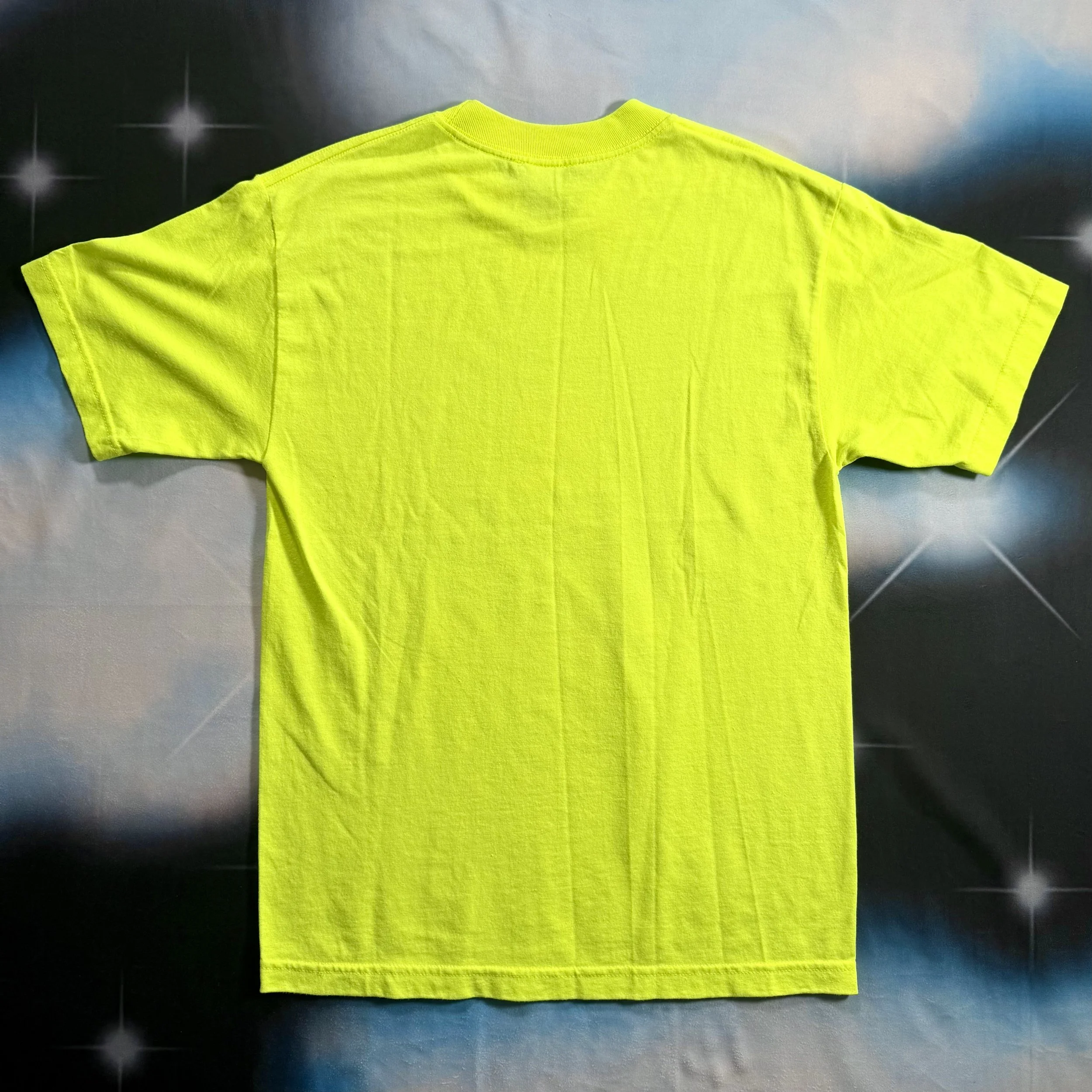 back of neon yellow shirt against a y2k style star backdrop
