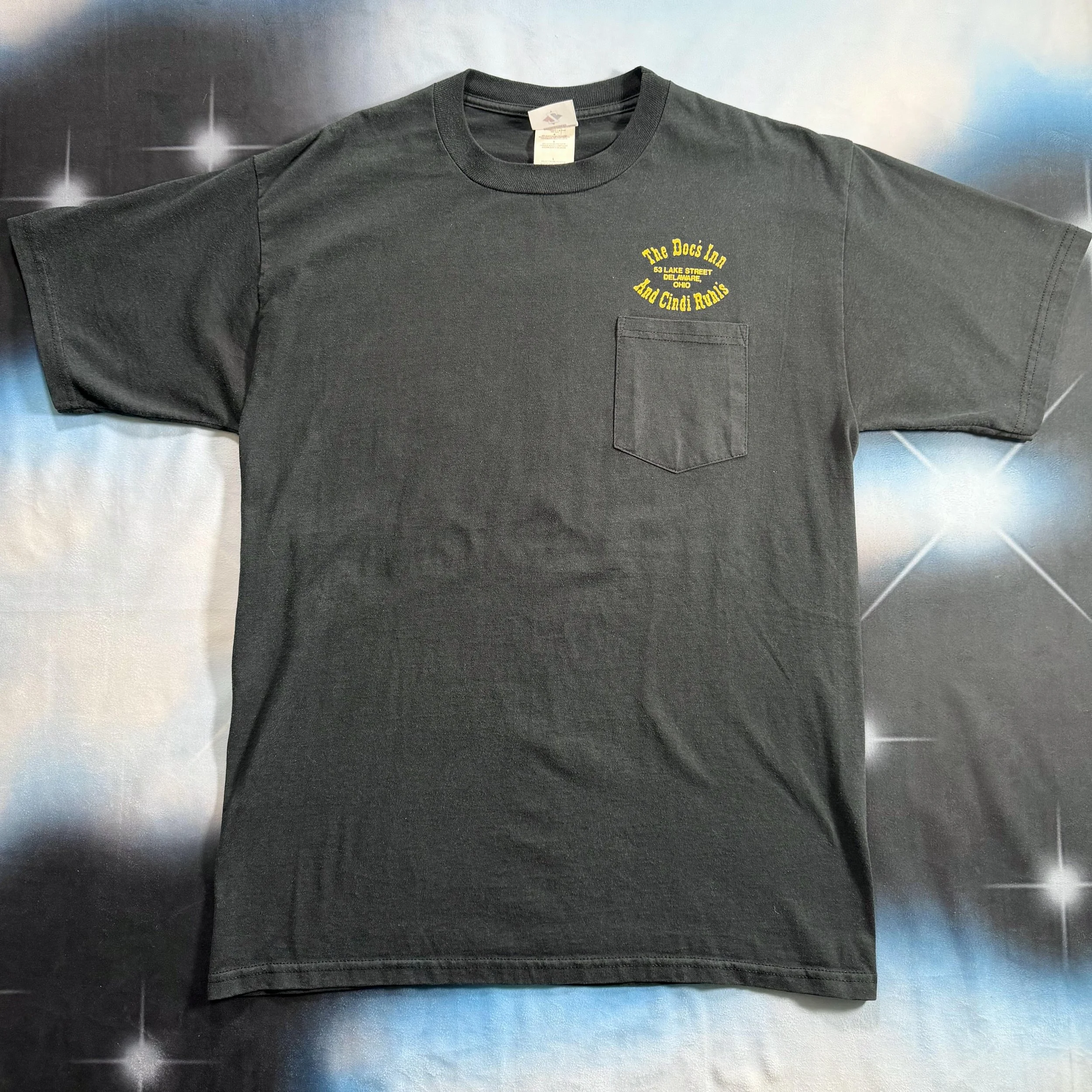 vintage shirt with charcoal fade and bright yellow contrasting text above front chest pocket