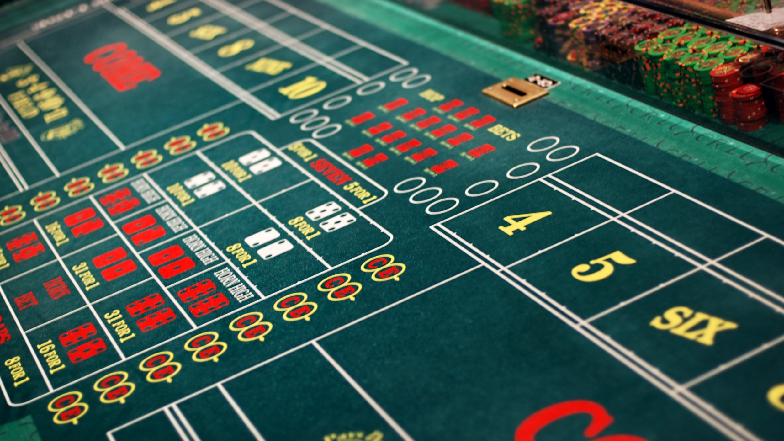 Close-up of a craps table in a casino with chips and betting areas visible.