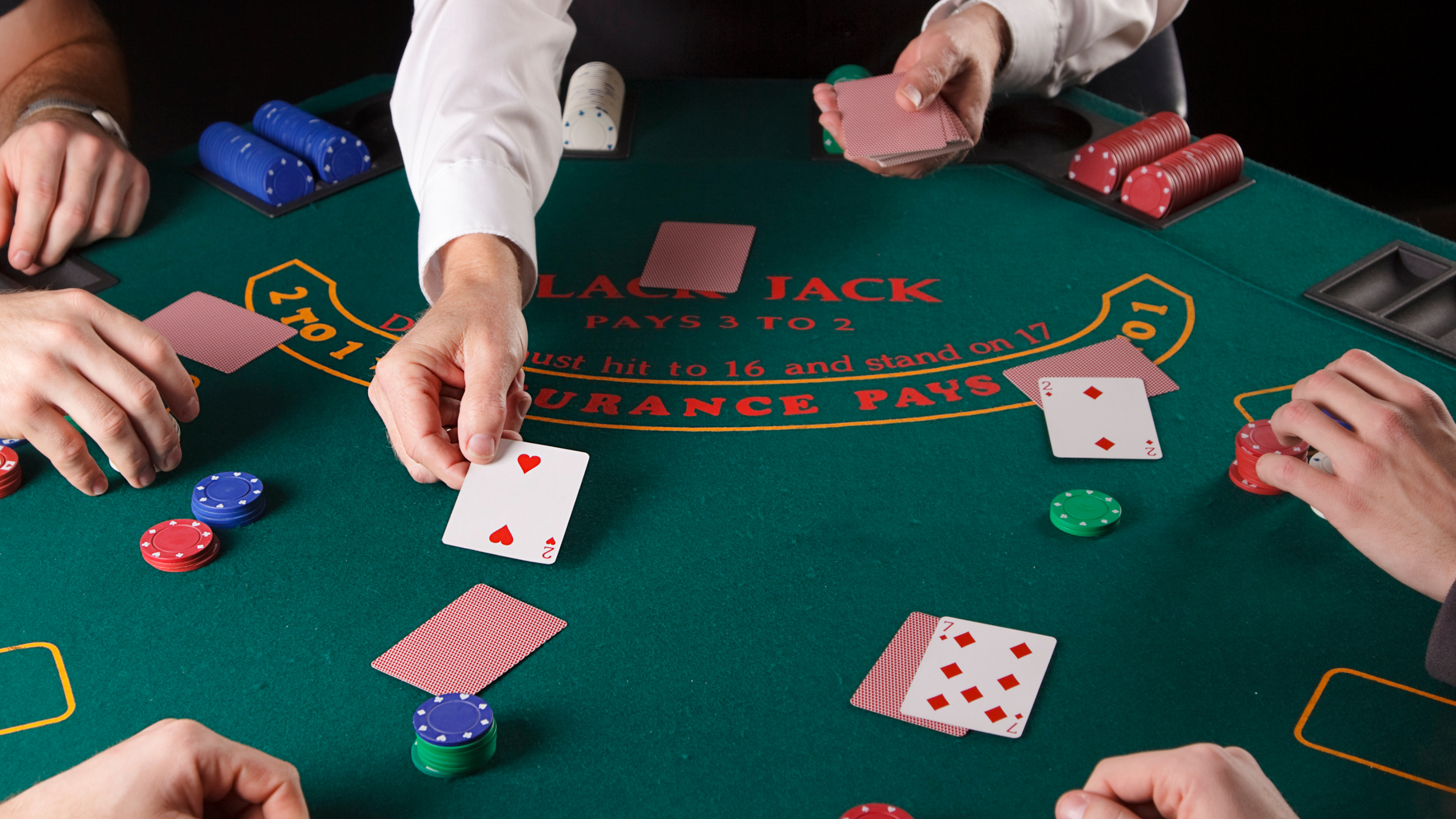 Blackjack table with dealer and players, poker chips, and playing cards