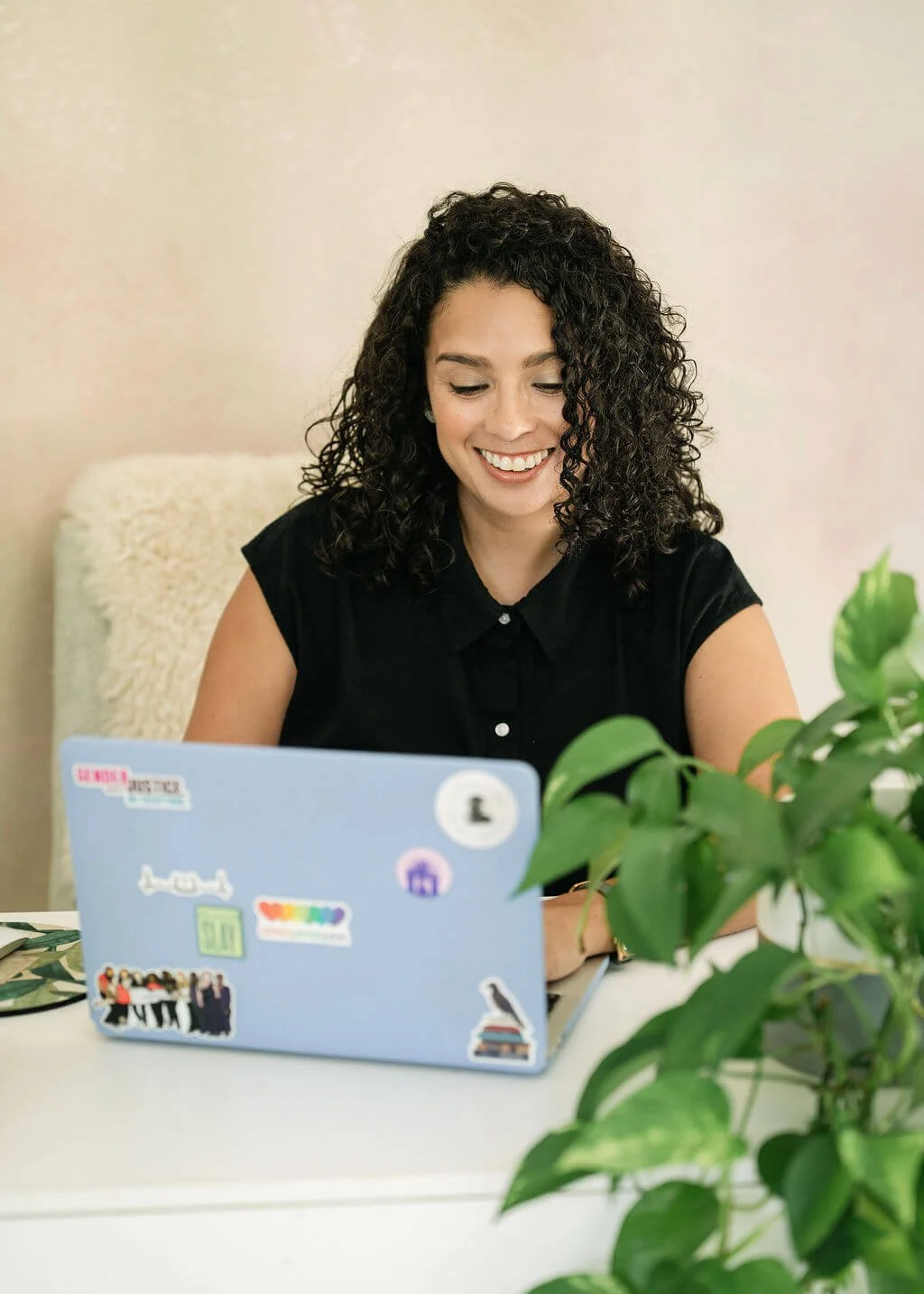 Christina Martin Kenny, nonprofit fundraising consultant, smiling at laptop while working on nonprofit fundraising strategies.