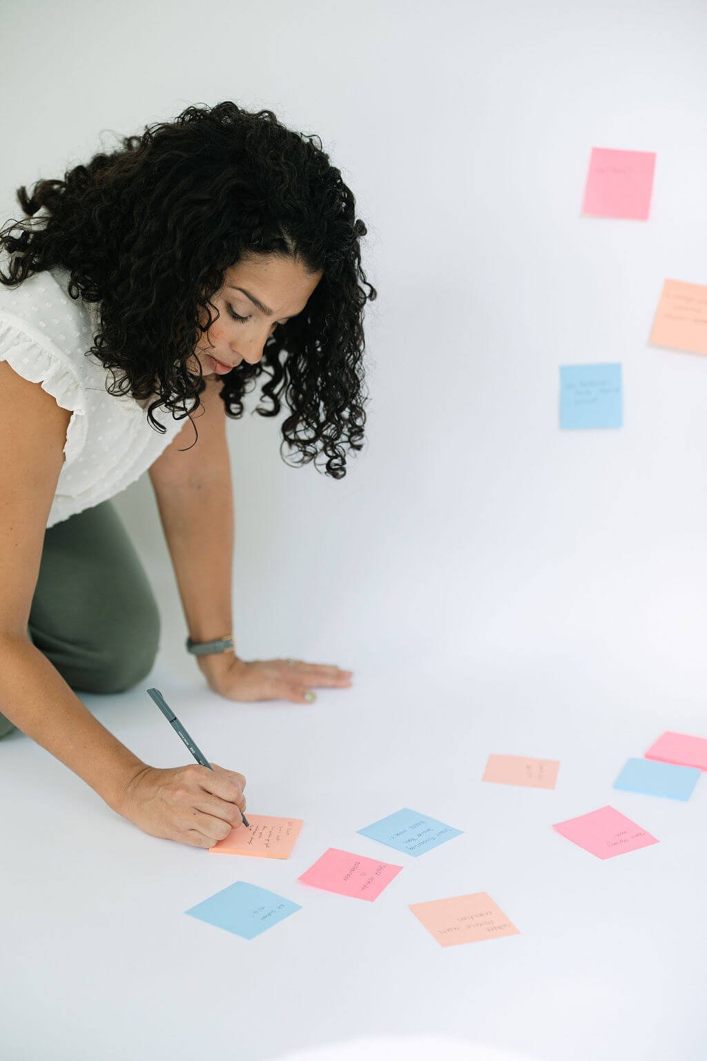 A nonprofit fundraising consultant mapping out a nonprofit funding strategy with sticky notes on the floor and wall.