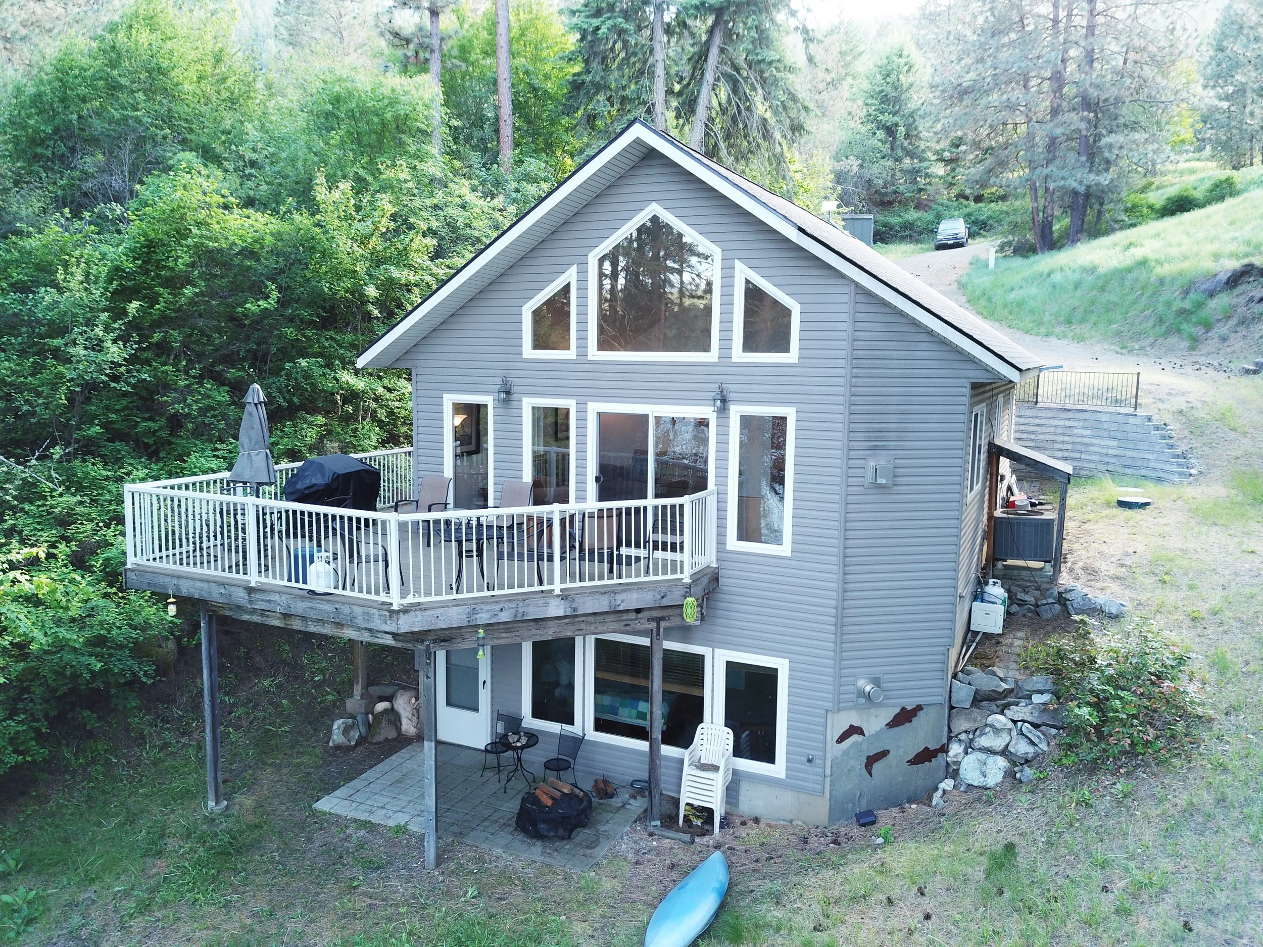 Happy client home in Northeast Washington featuring a beautiful lakefront retreat with a wraparound deck, represented by trusted Colville REALTOR® Lucas Hamlin.
