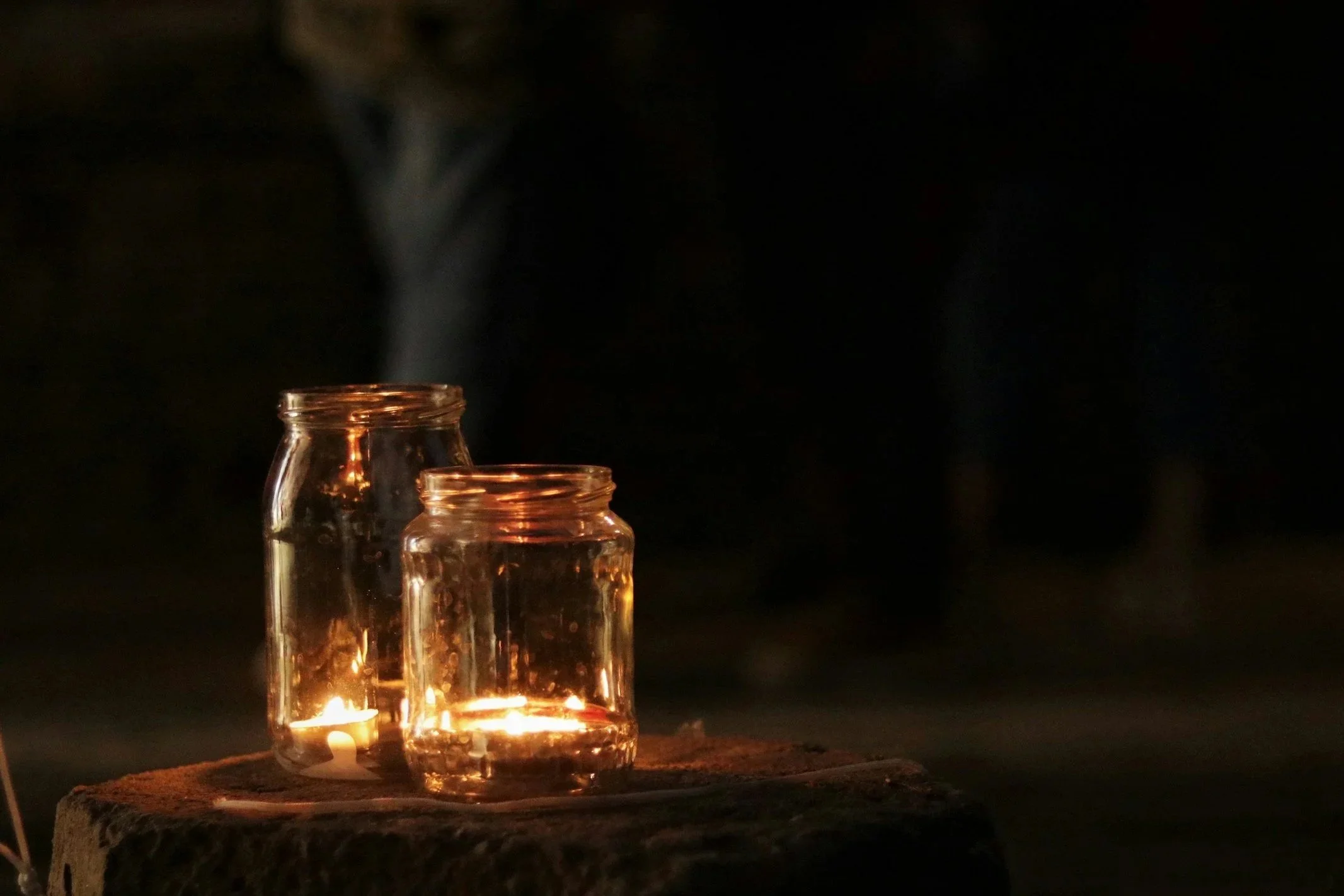 Scenic landscape featuring a mountain range, a lake, and rolling hills with sparse vegetation.