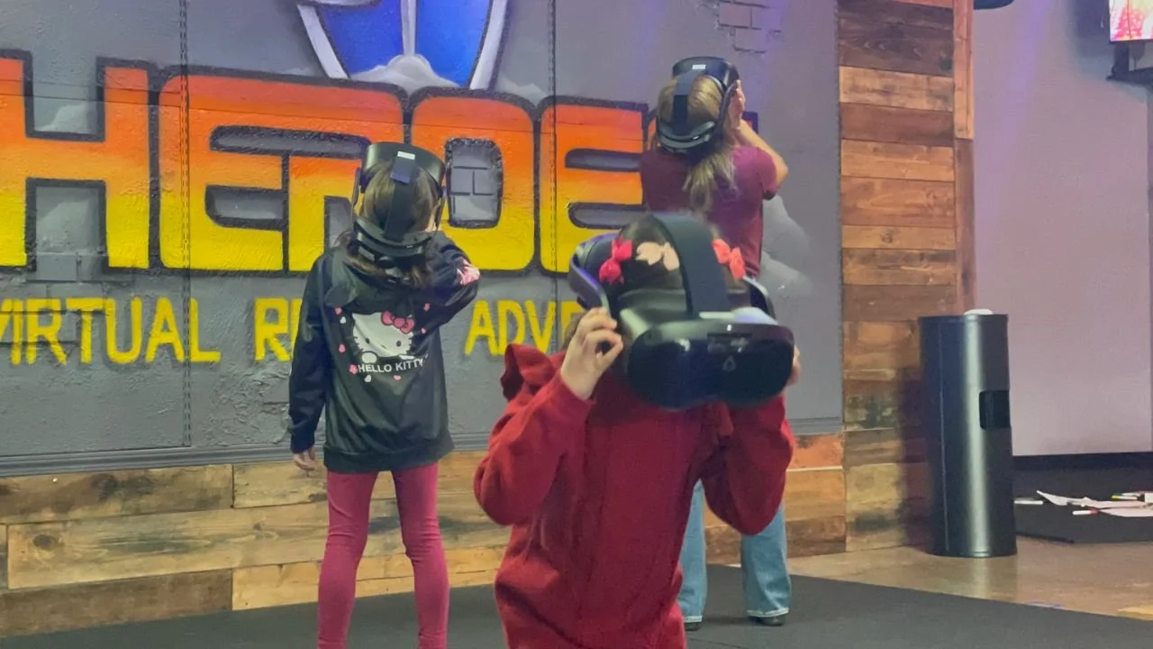Kids exploring an interactive virtual reality game while wearing VR headsets in a free-roam VR arena.