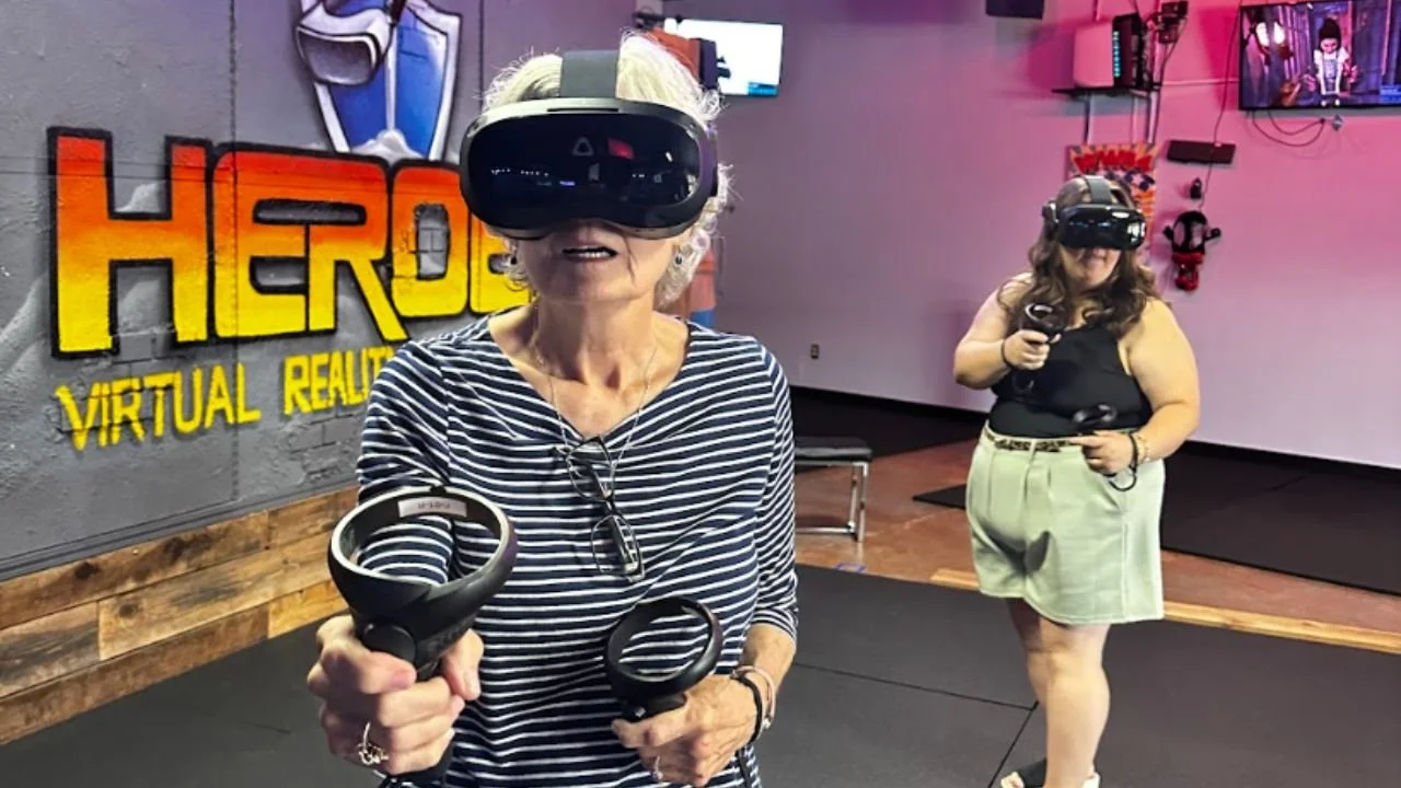 Adults enjoying an immersive virtual reality experience with VR headsets and controllers at HEROES VR Adventures.
