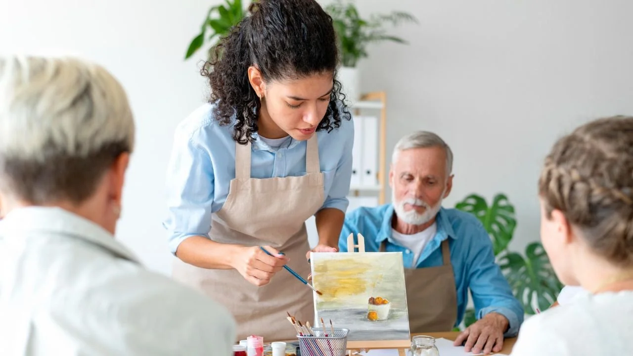 A group participating in a guided painting class, a creative choice for indoor birthday party ideas.