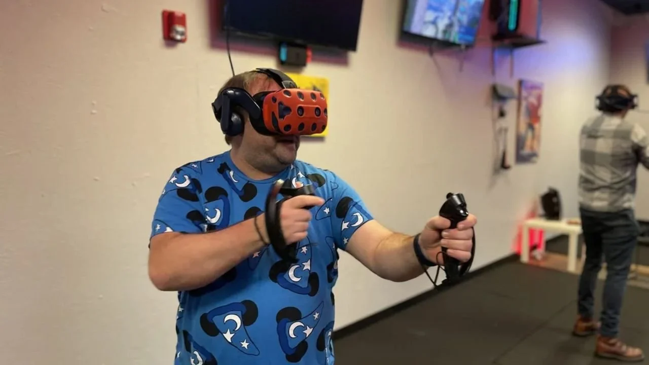 Man using VR headset and controllers inside HEROES VR Adventures