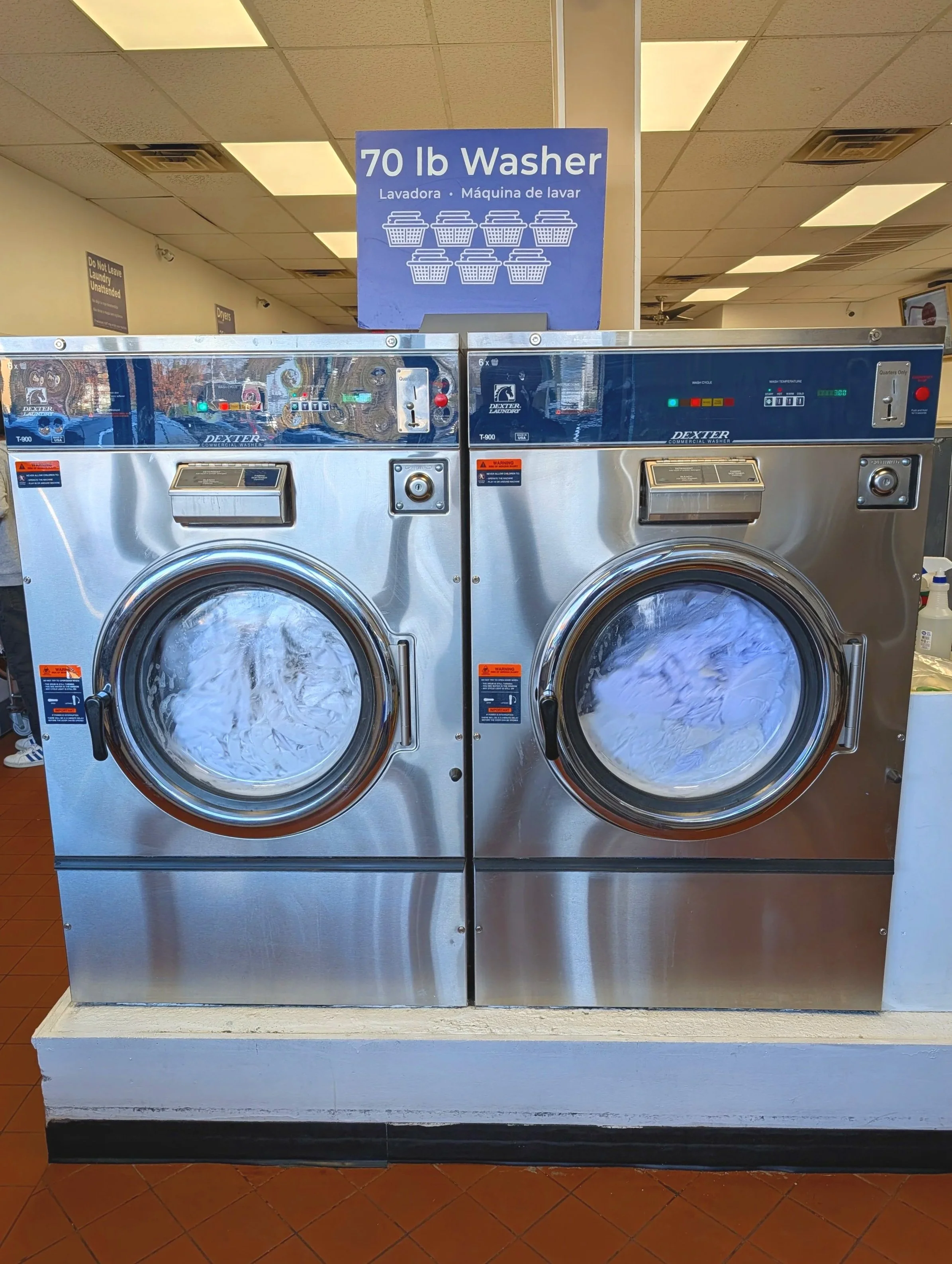 Folded tshirts on top of a washer at a laundromat