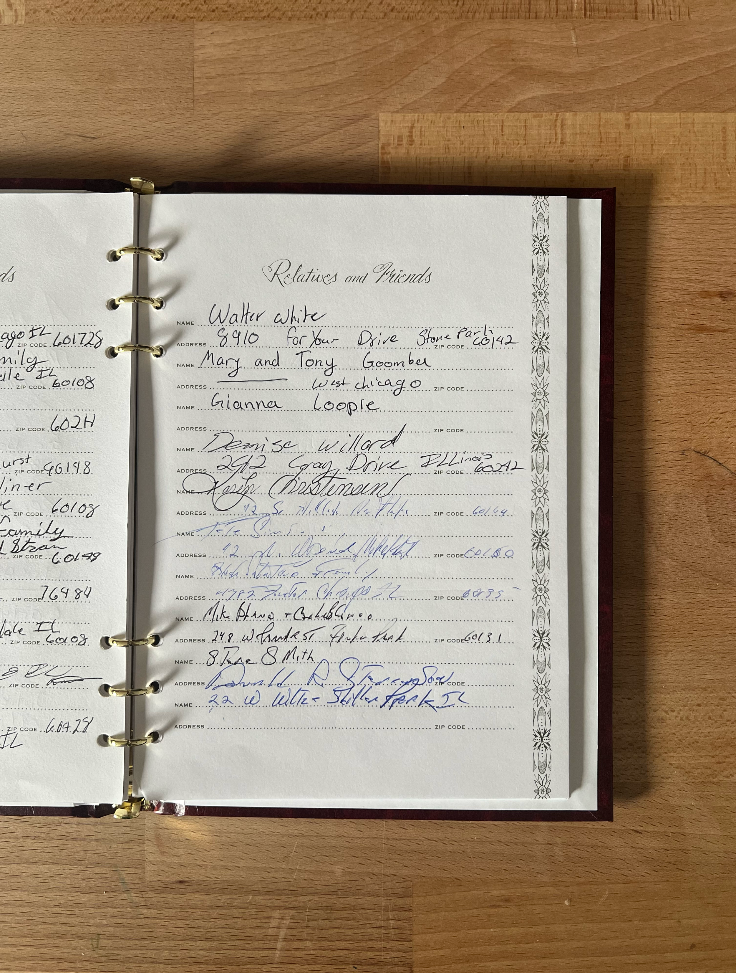 A close-up photograph of a page from a traditional paper guestbook, containing messy handwritten addresses and names.