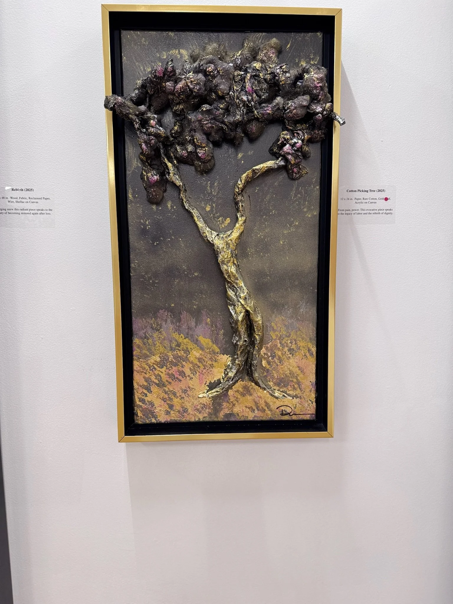 Mixed media artwork depicting a gnarled tree with purple and pink blossoms, framed and mounted on a white wall.