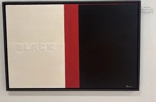 Artwork divided into two sections: the left is off-white with the word 'BLACK' embossed, and the right is black with the word 'WHITE' embossed, separated by a red stripe.