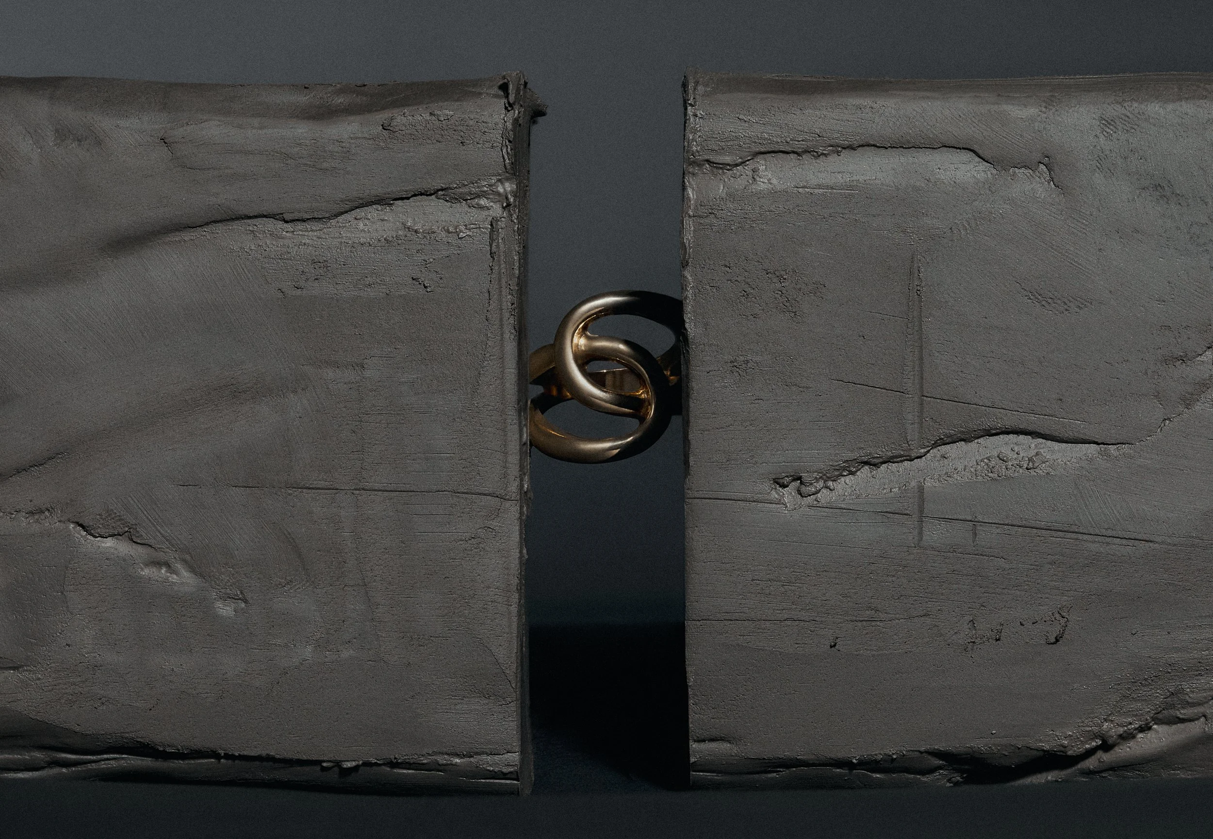 A black ring positioned between two broken concrete blocks.